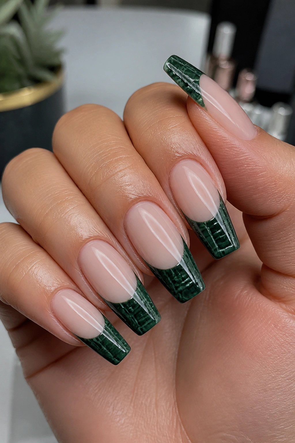 Close-up of dark green croc-texture French tips on nails