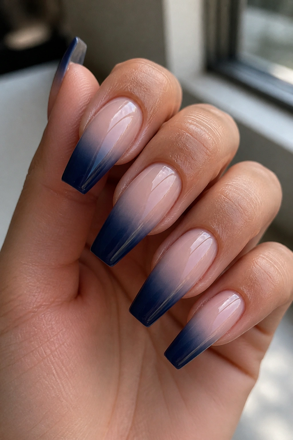 Close-up of coffin nails with dark blue French fade