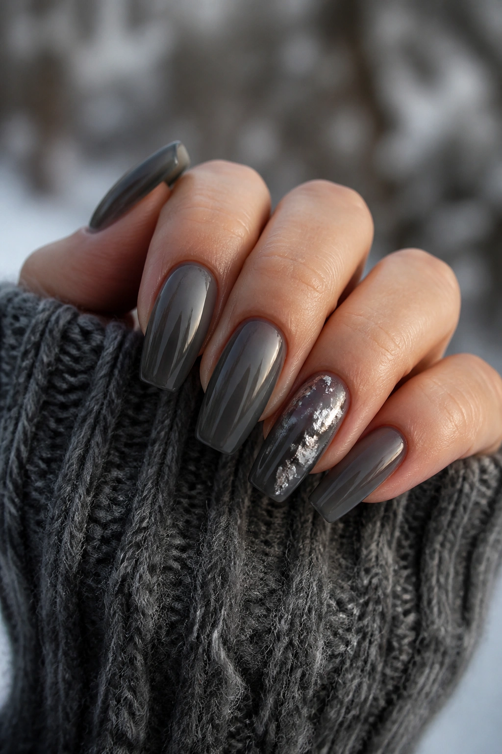Close-up of dark grey jelly coffin nails with translucent depth on a real hand.