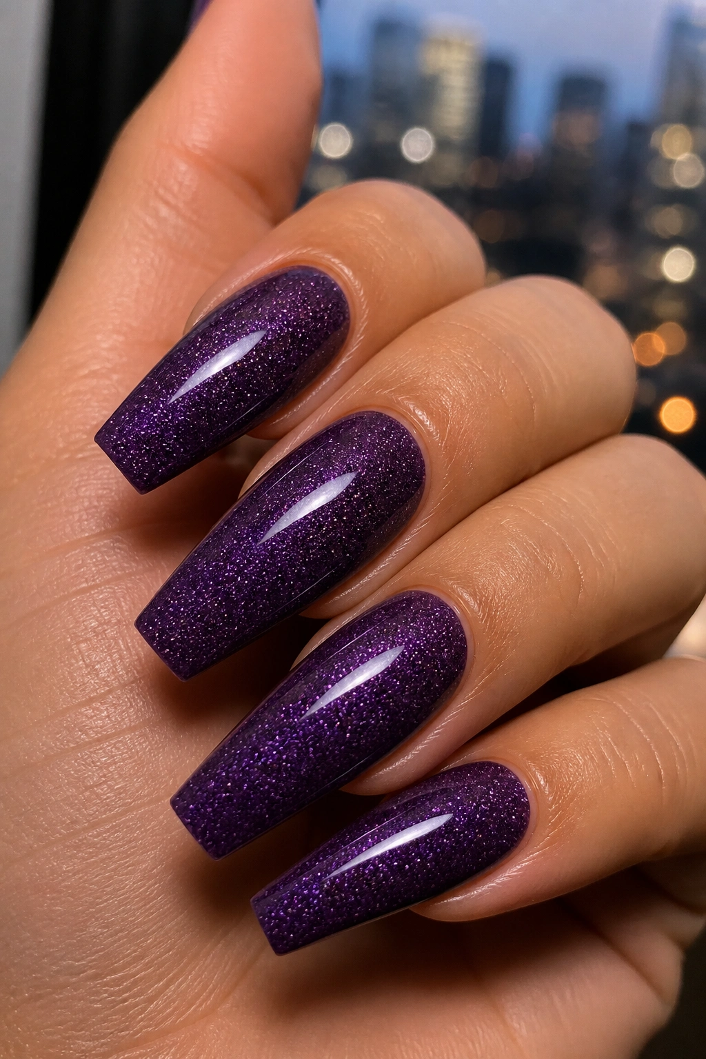 Close-up of dark orchid coffin nails with micro glitter on a real hand