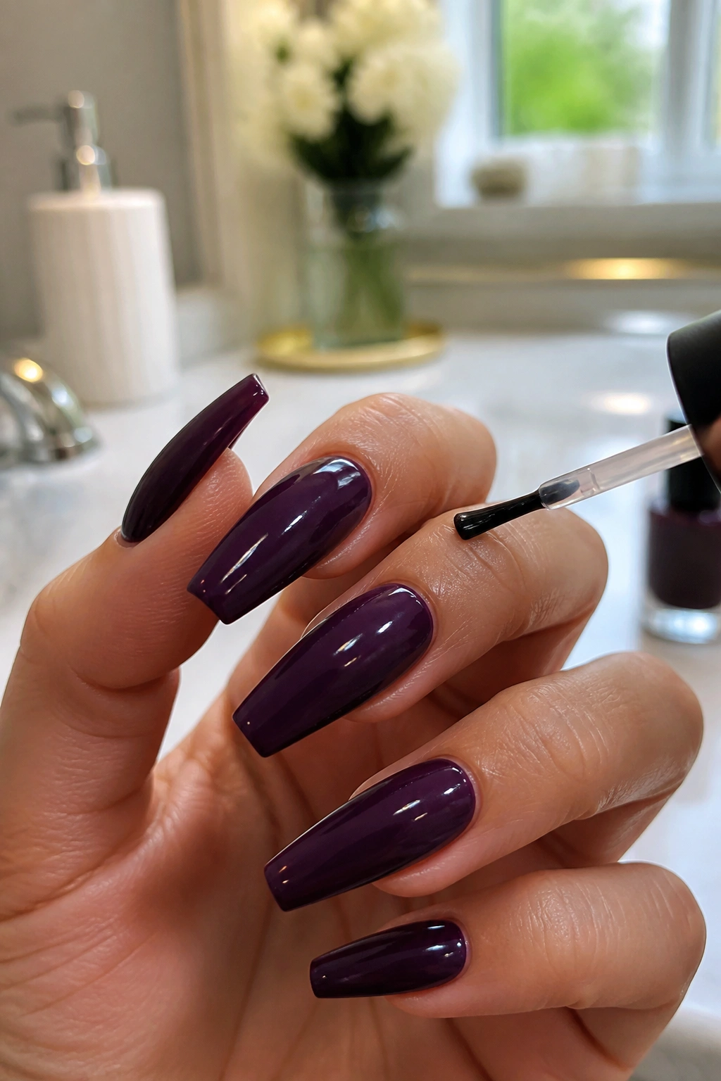 Close-up of a real hand with dark purple coffin nails showing edge sealing with top coat