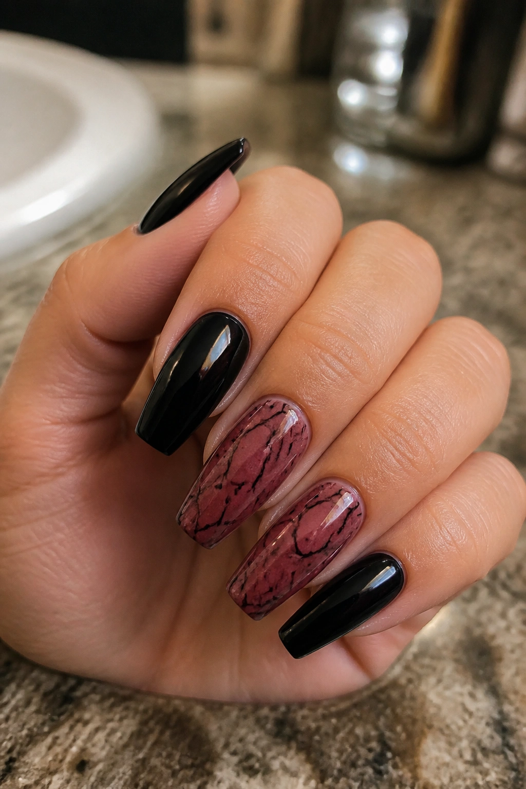 Close-up of dark rose marble nails with black veining