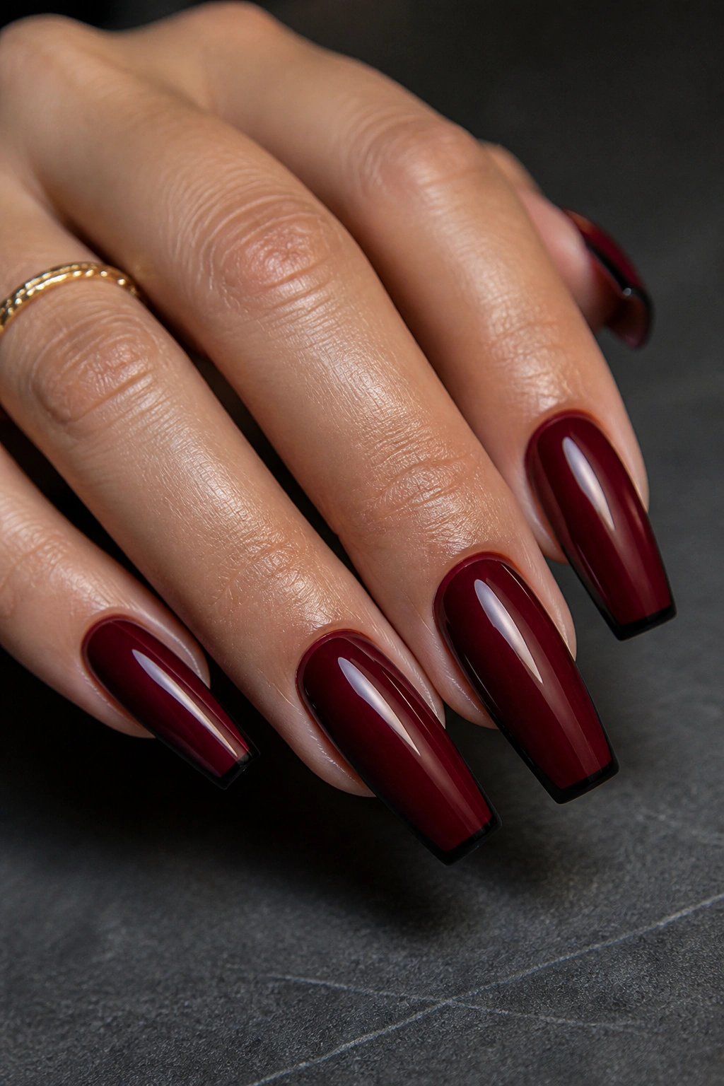 Close-up of deep maroon nails with black-edged tips