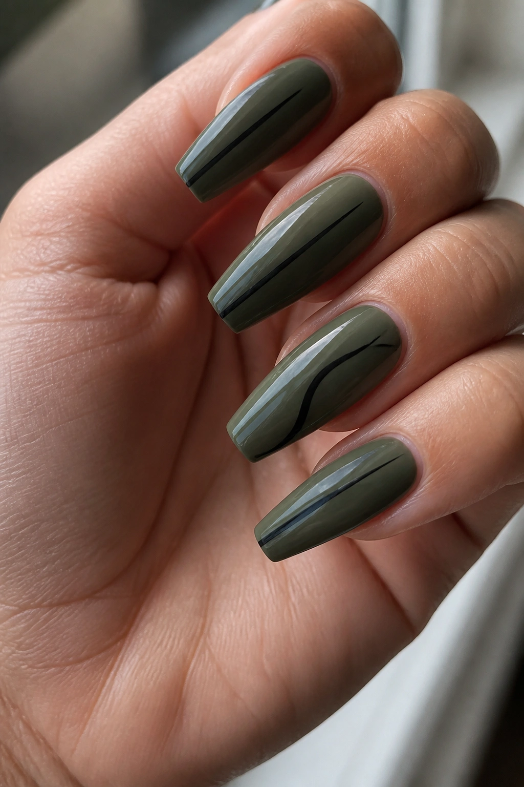 Close-up of deep sage coffin nails with fine black line details