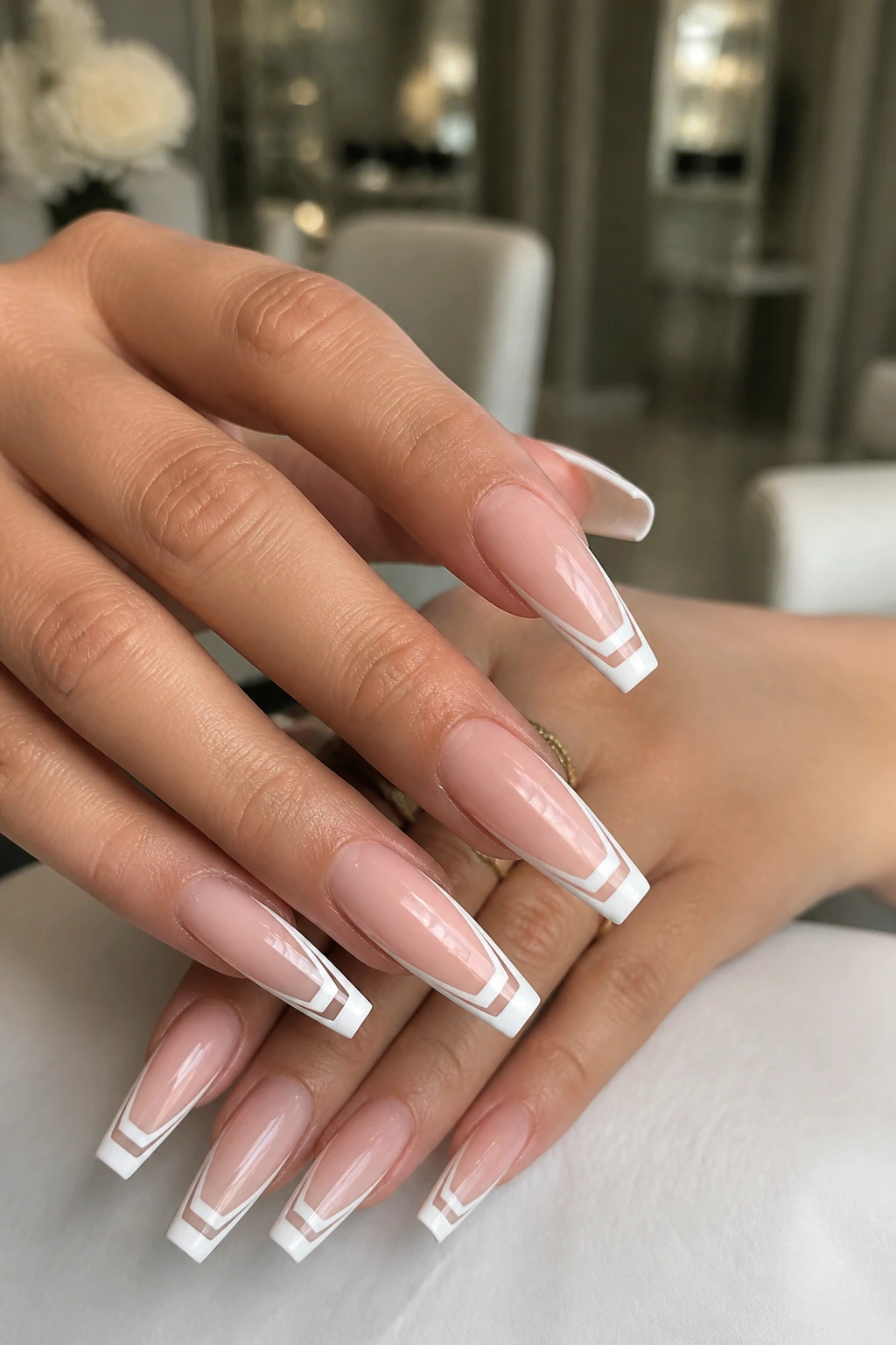 Close-up of hands with Double-Line French Tips on coffin nails showing two white lines and a nude gap