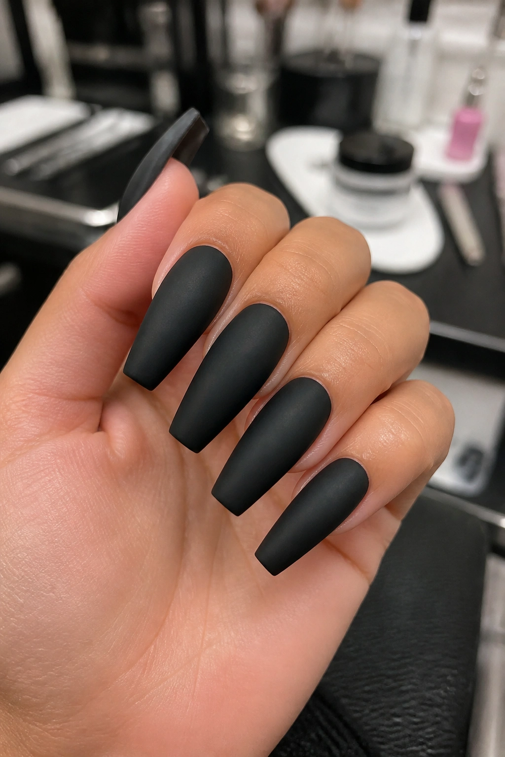 Hands with durable matte coffin nails in a salon setting, showing structured overlay.