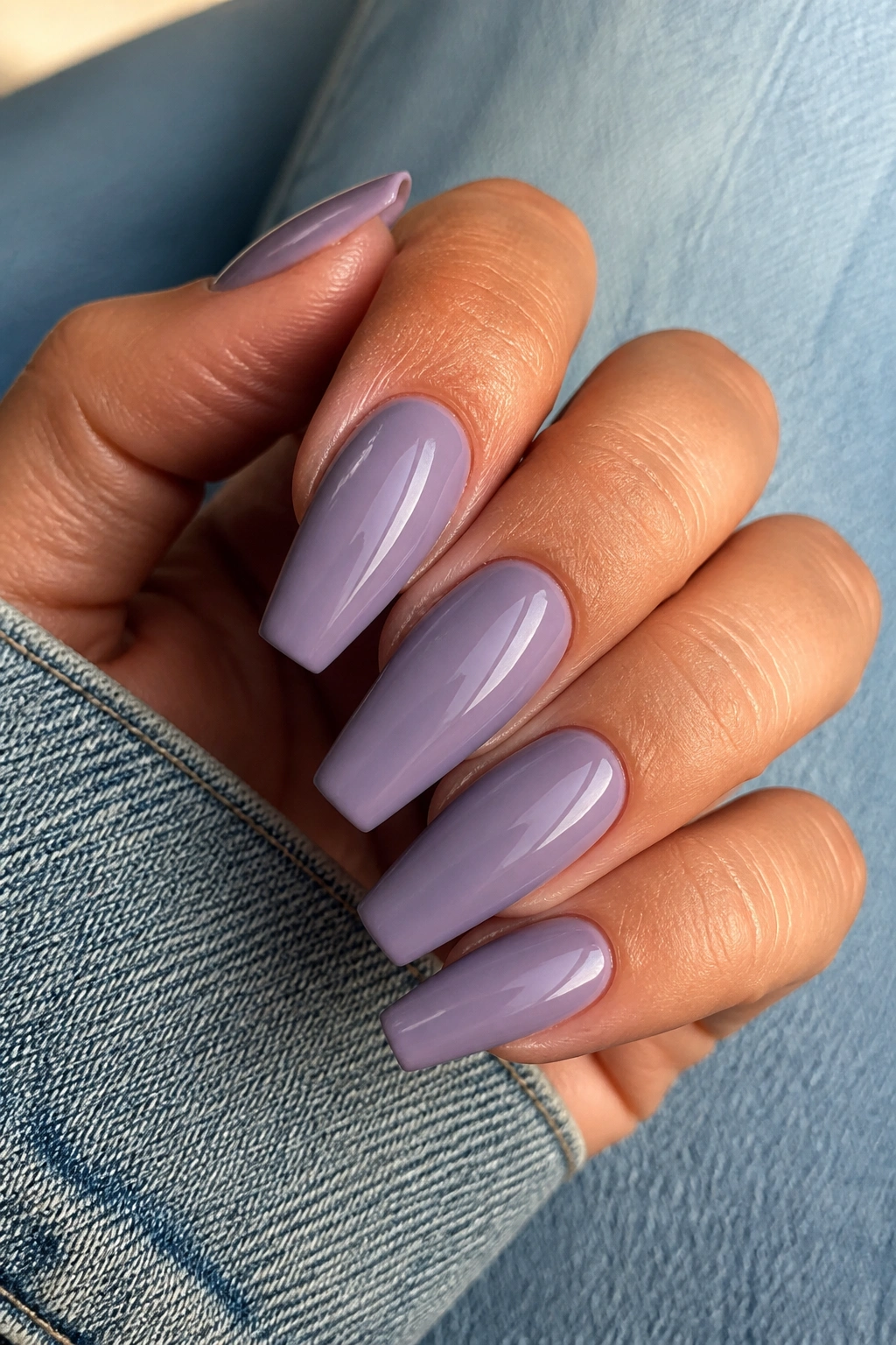 Close-up of dusty lilac coffin nails on a real hand with glossy finish.