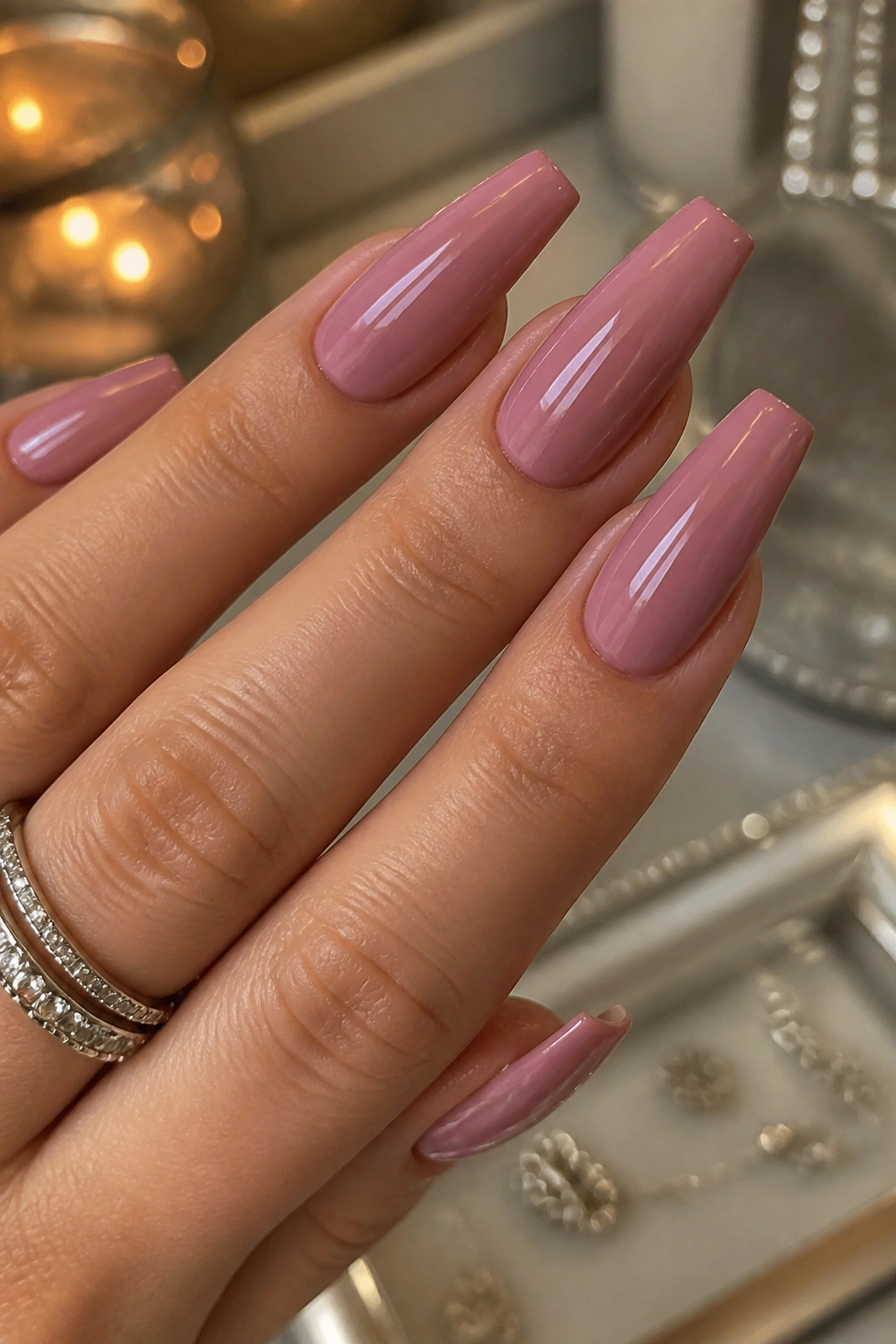 Close-up of dusty mauve-pink glossy coffin nails on a real hand