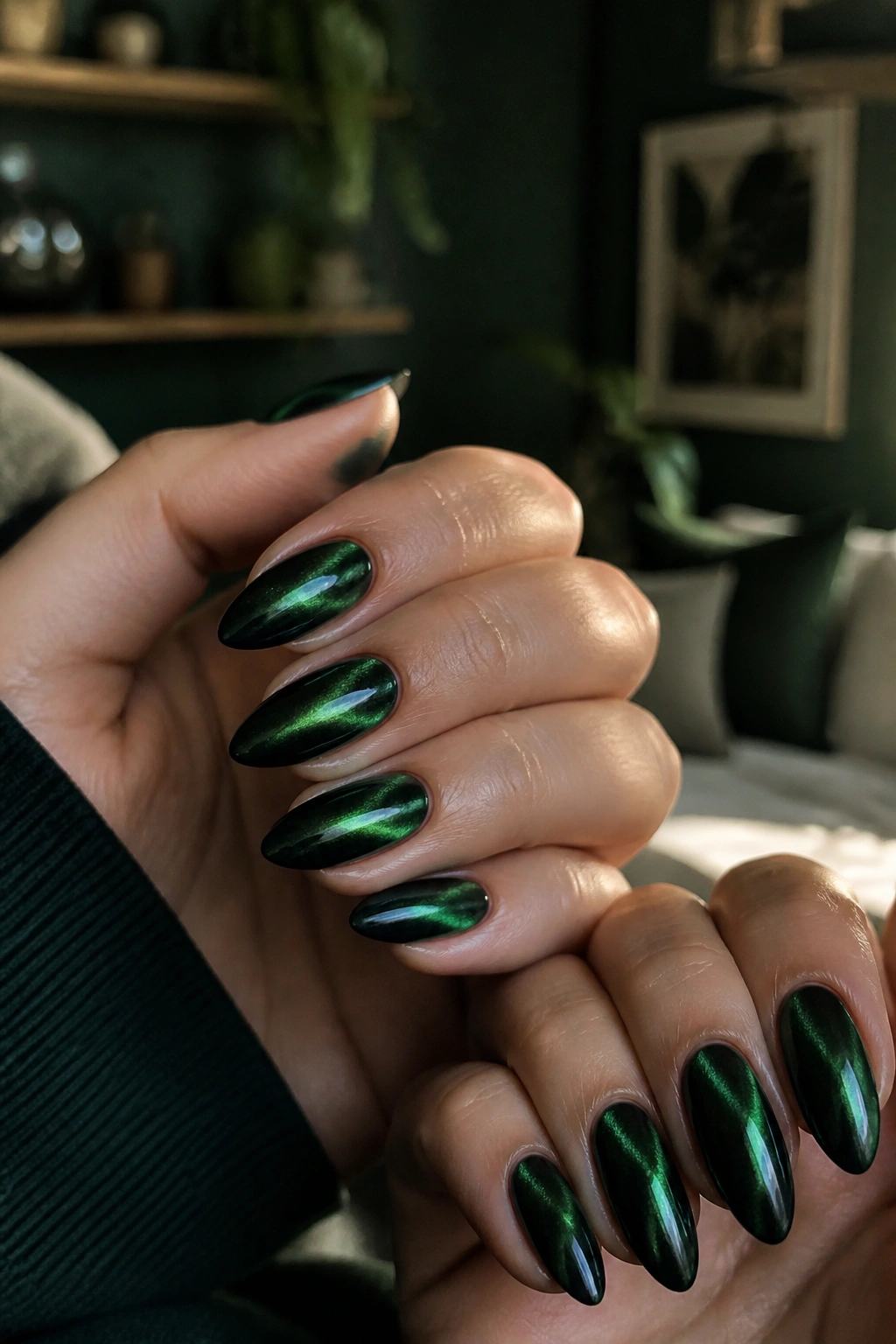 Close-up of emerald cat-eye almond nails catching light on real hands