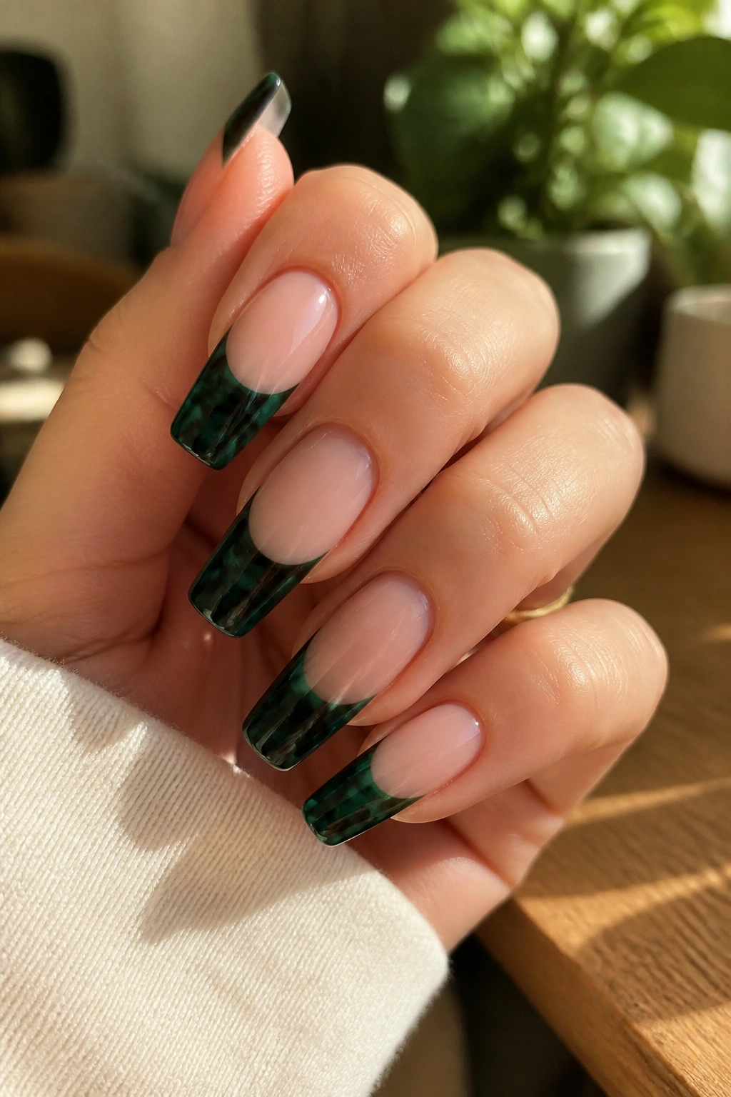 Close-up of emerald tortoiseshell coffin nails on a sheer nude base