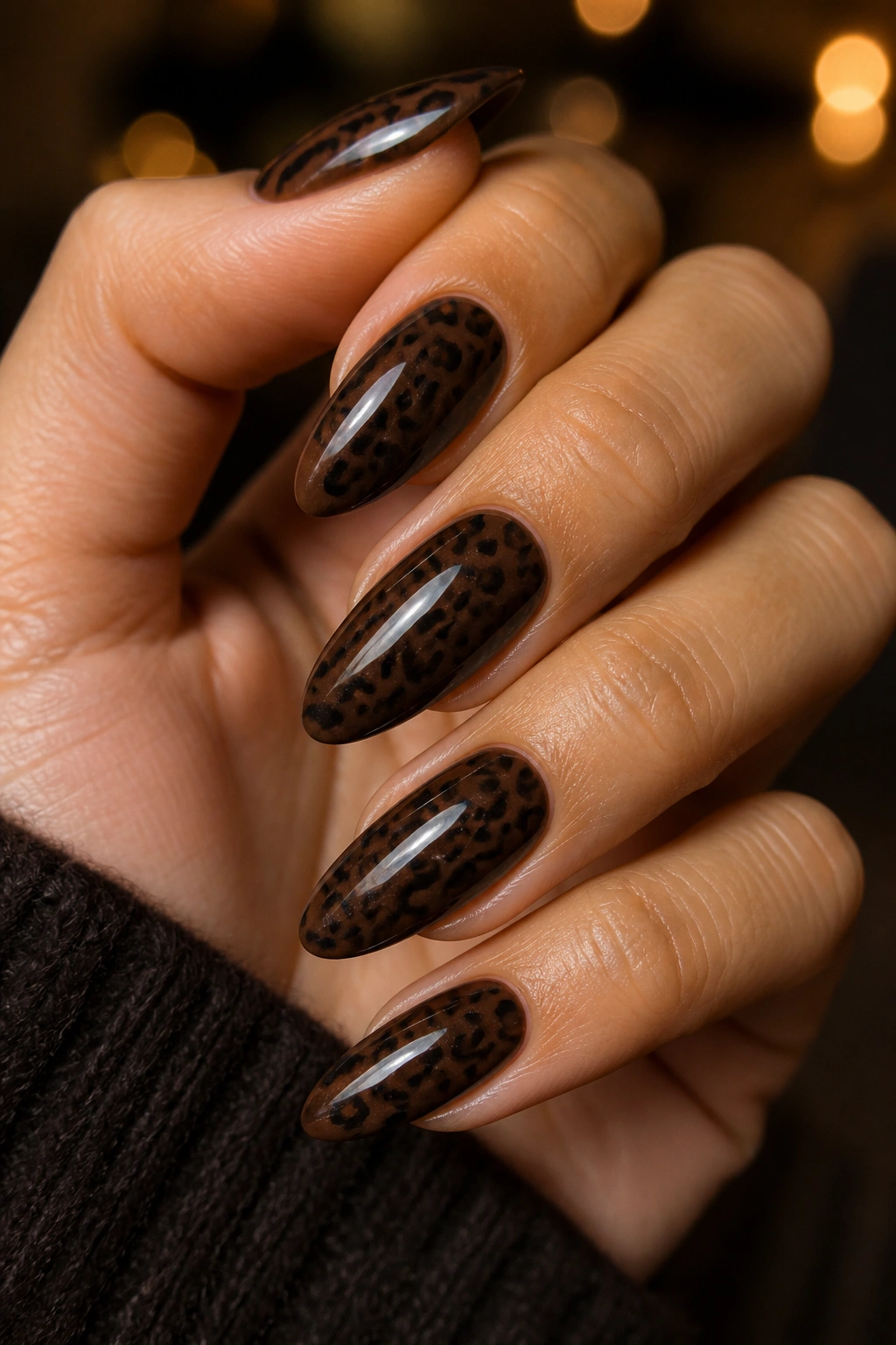 Close-up of espresso-brown cheetah nails with glossy topcoat