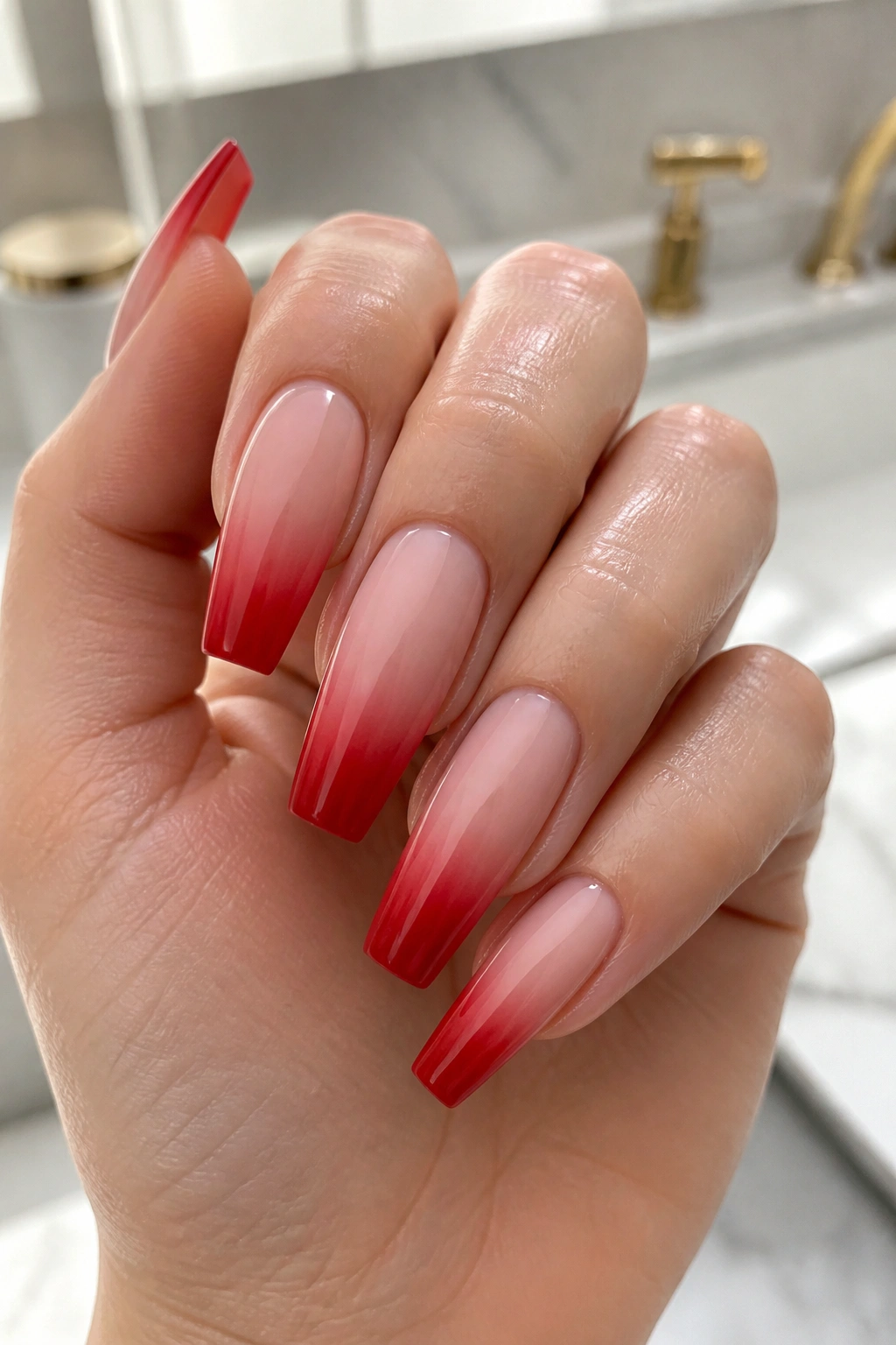 Close-up of soft red French fade coffin nails