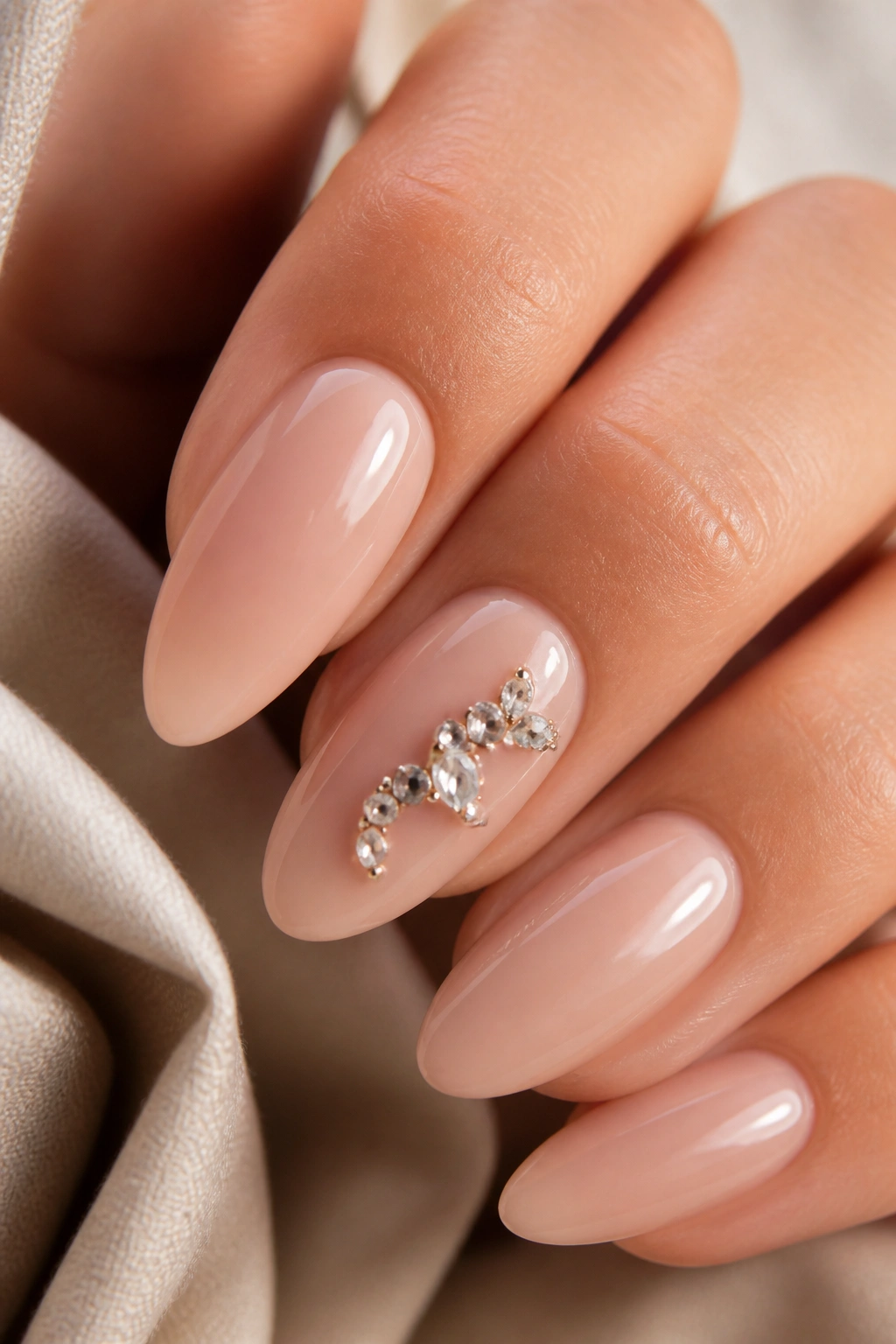 Almond nail with a gemstone accent forming an abstract initial shape