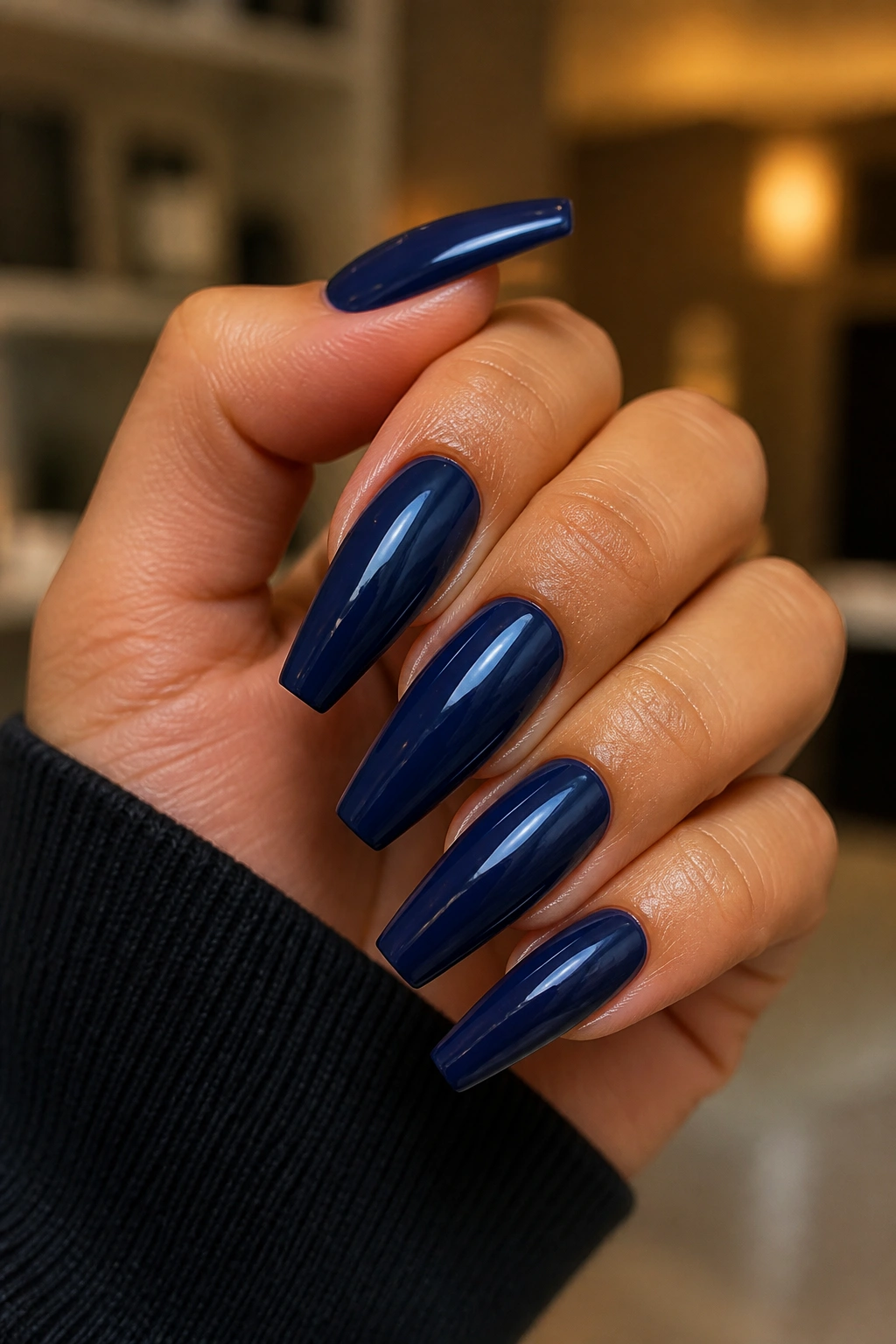 Close-up of a real hand with glossy navy coffin nails
