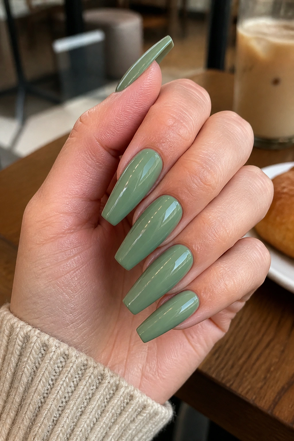 Close-up of glossy sage green coffin nails on real hand
