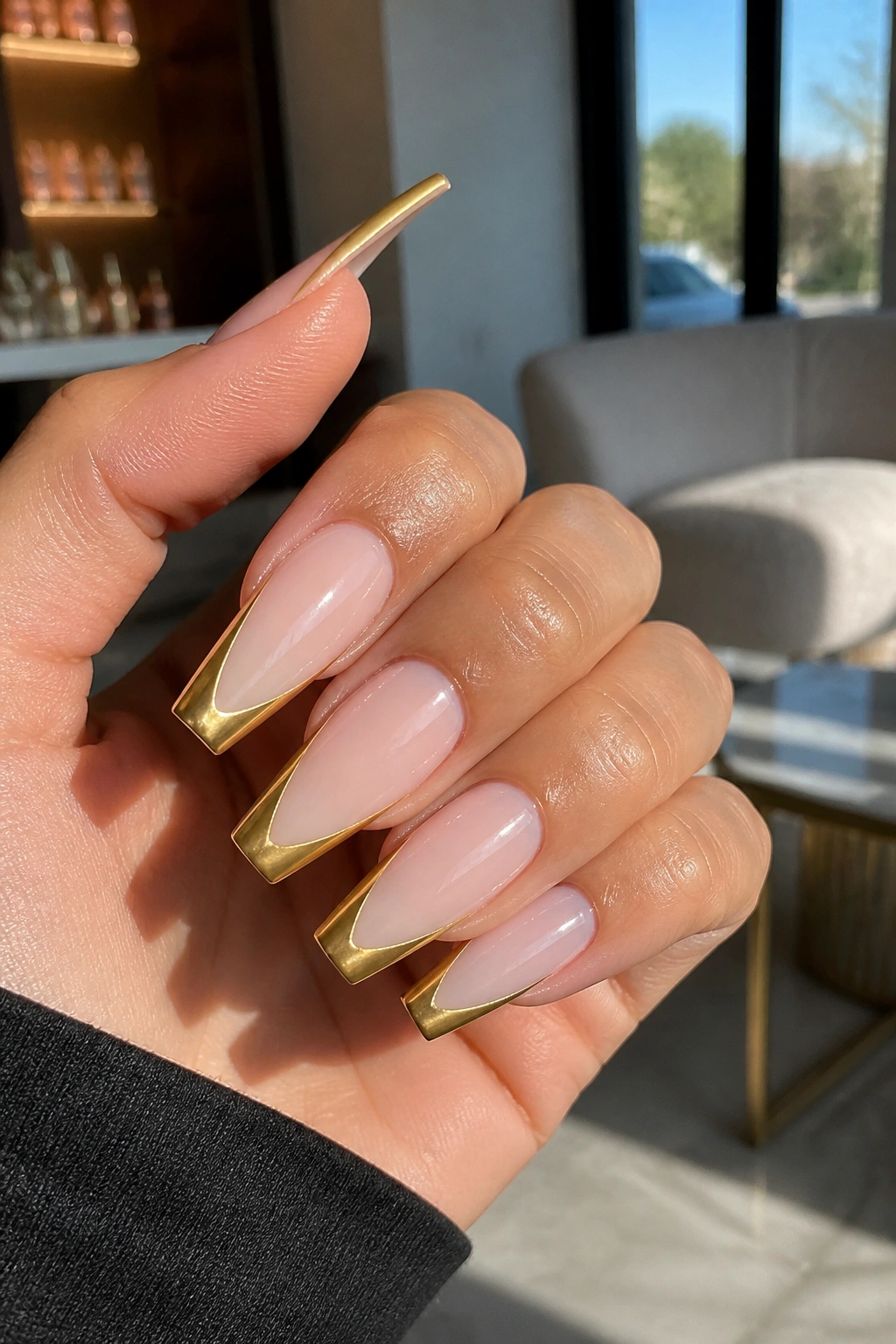 Close-up of gold French tip coffin nails with a sharp smile line