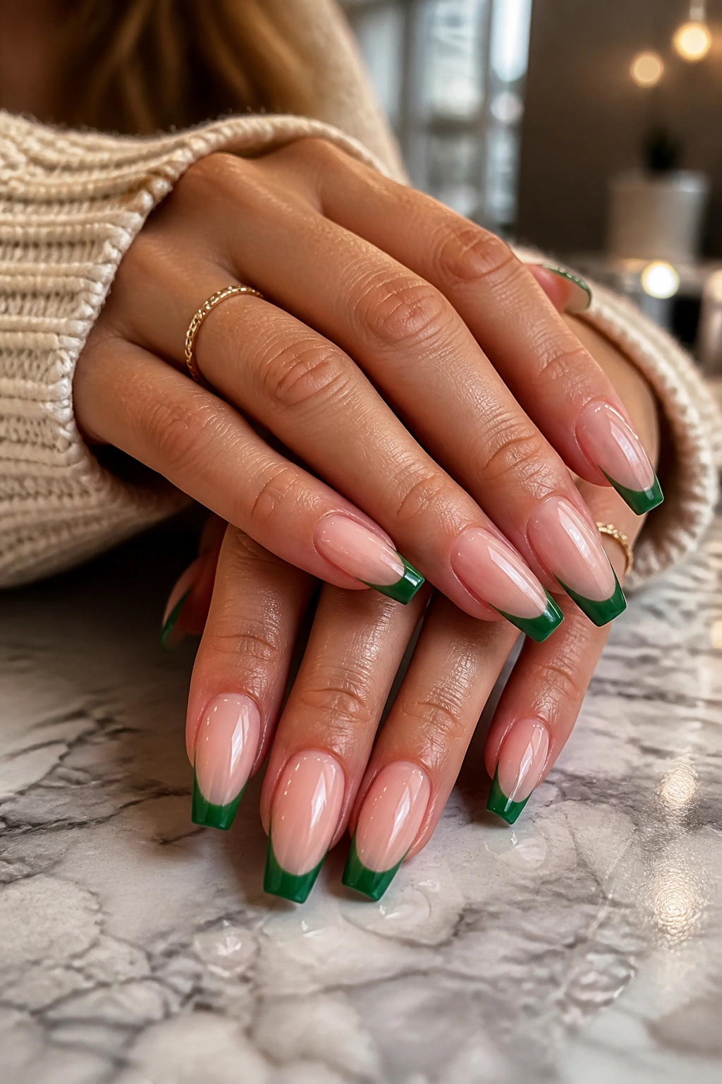 Close-up of green French tip coffin nails on a real hand in a salon.