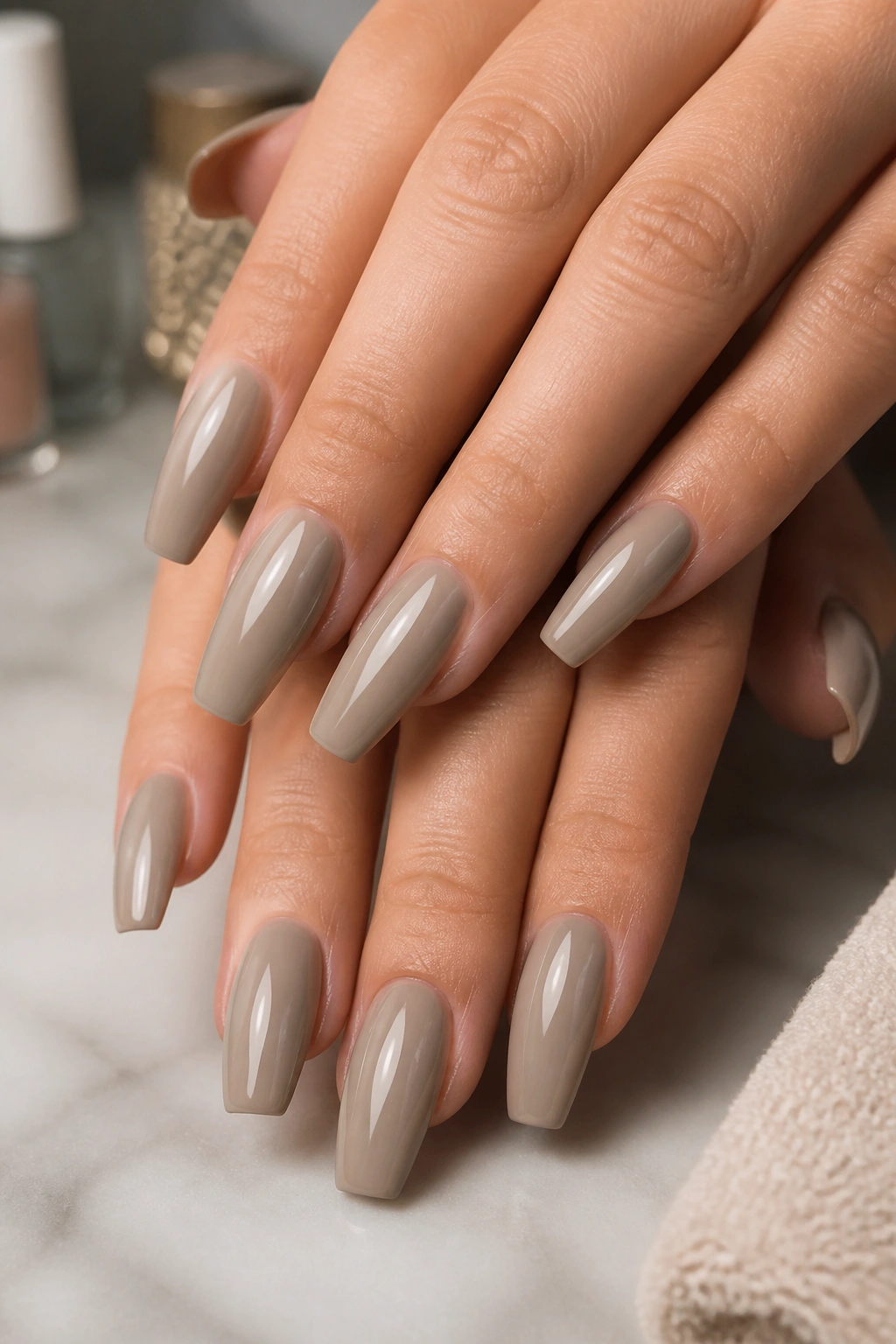 Close-up of greige coffin nails on a real hand in soft daylight