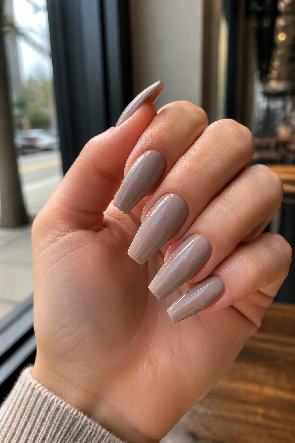 Close-up of cool greige nude coffin nails on a real hand