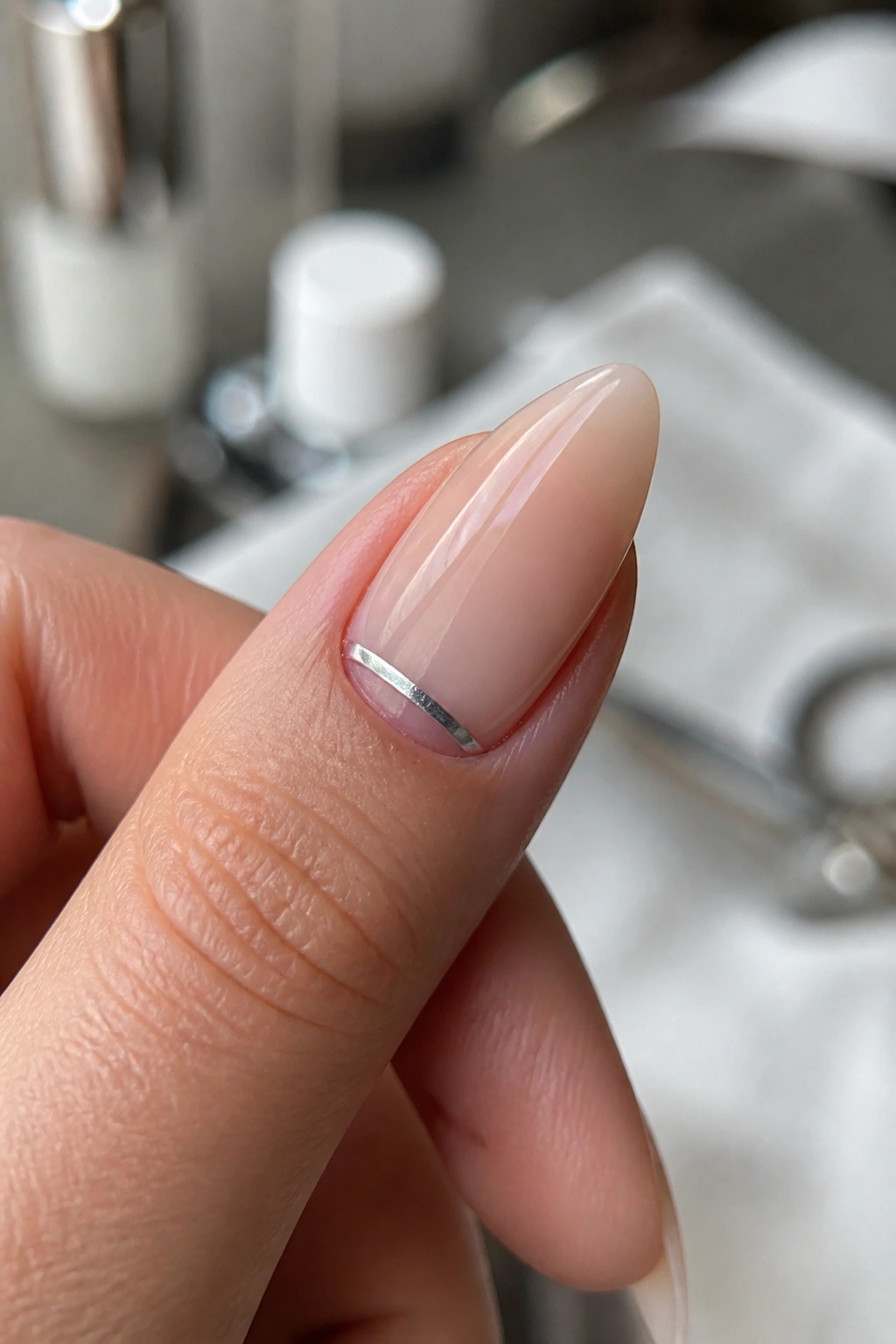 Almond nail with a slim silver half-moon near cuticle on bare nail