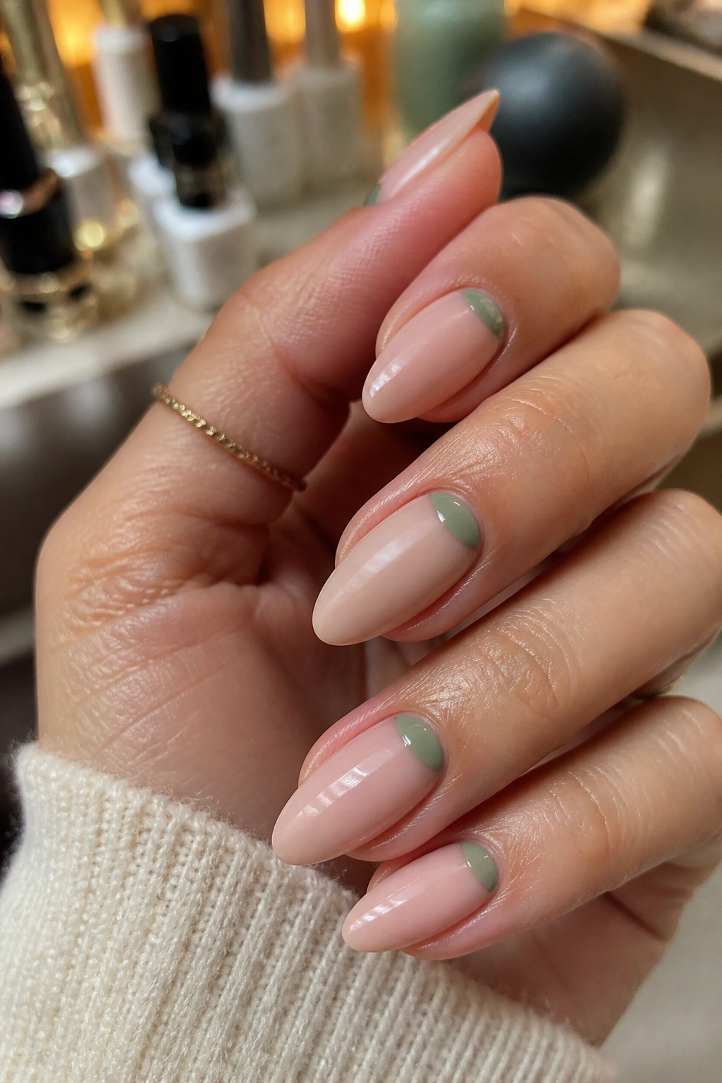 Almond nails with a sage green half-moon at the cuticle on nude base