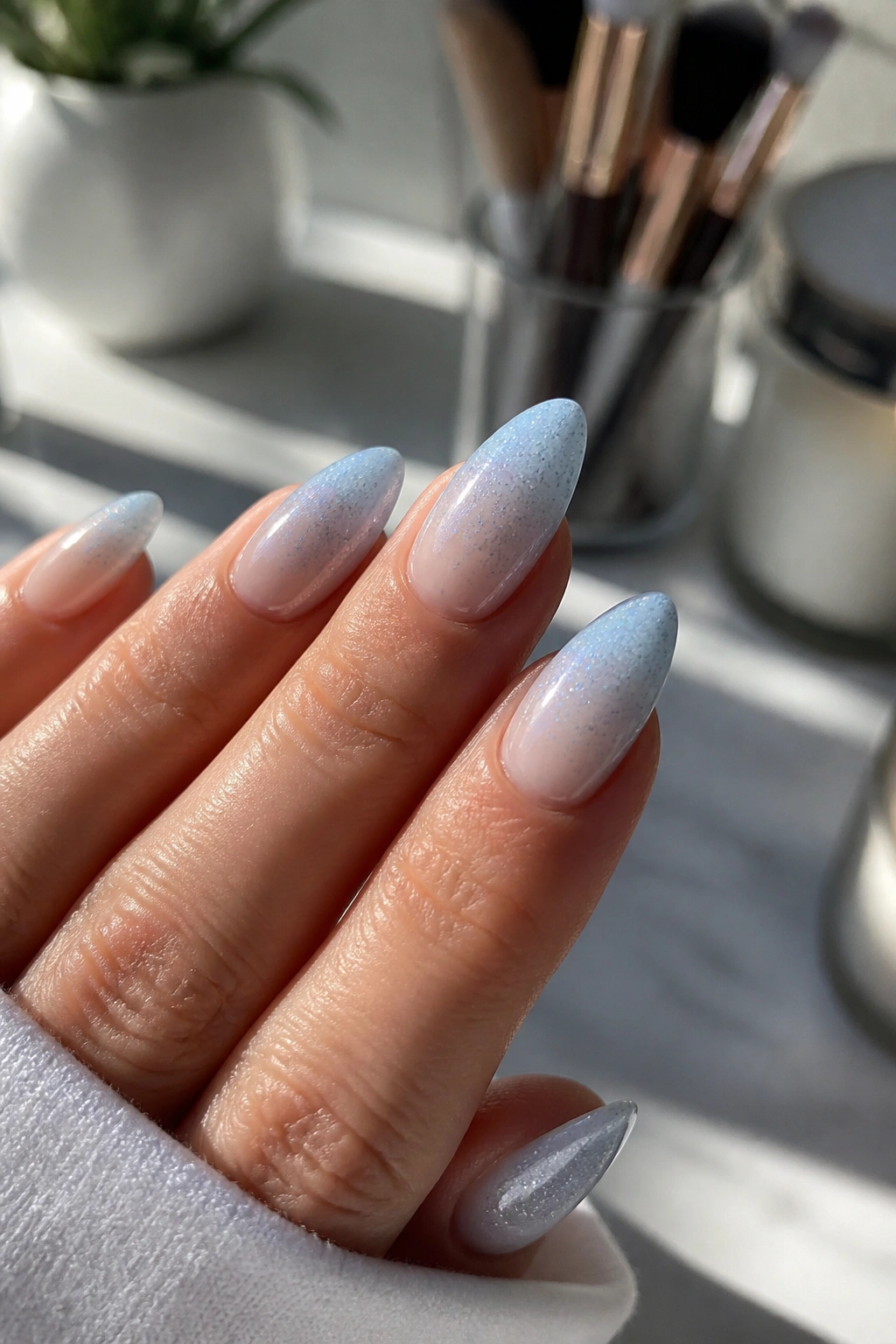 Almond nail with pale blue base and fine glitter gradient