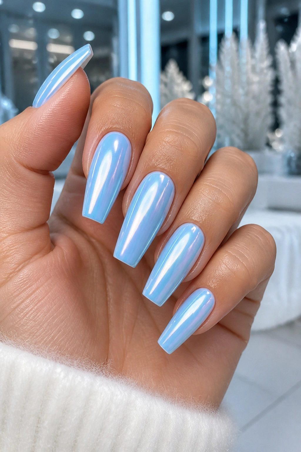 Close-up of real hand with icy blue chrome coffin nails reflecting light