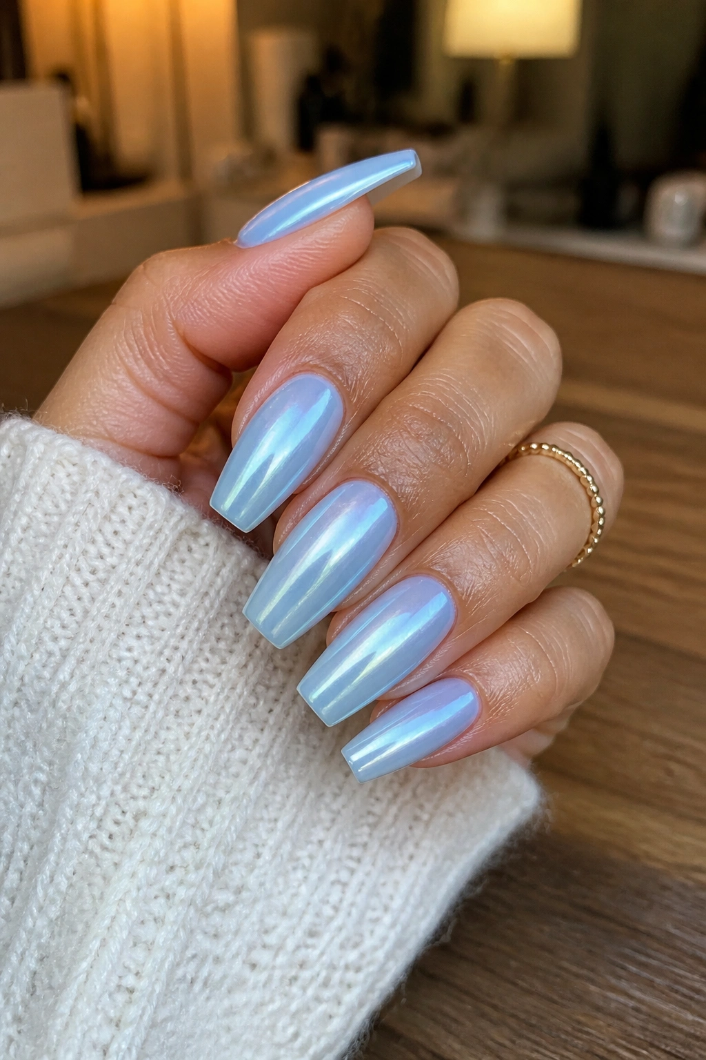 Close-up of coffin nails with icy chrome over soft baby blue glaze on a real hand
