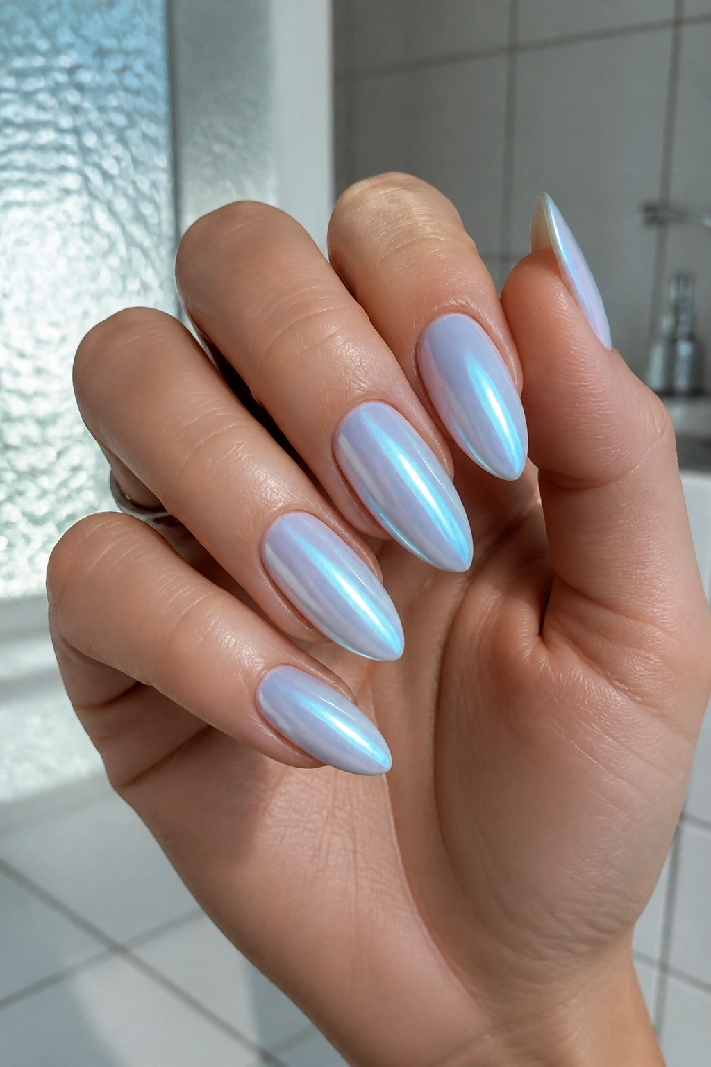 Almond nails with icy chrome and blue tint on real hand