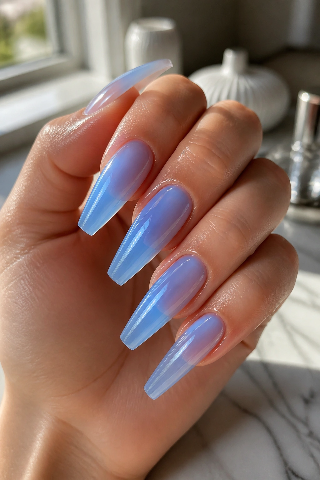 Close-up of translucent jelly baby blue coffin nails on a real hand