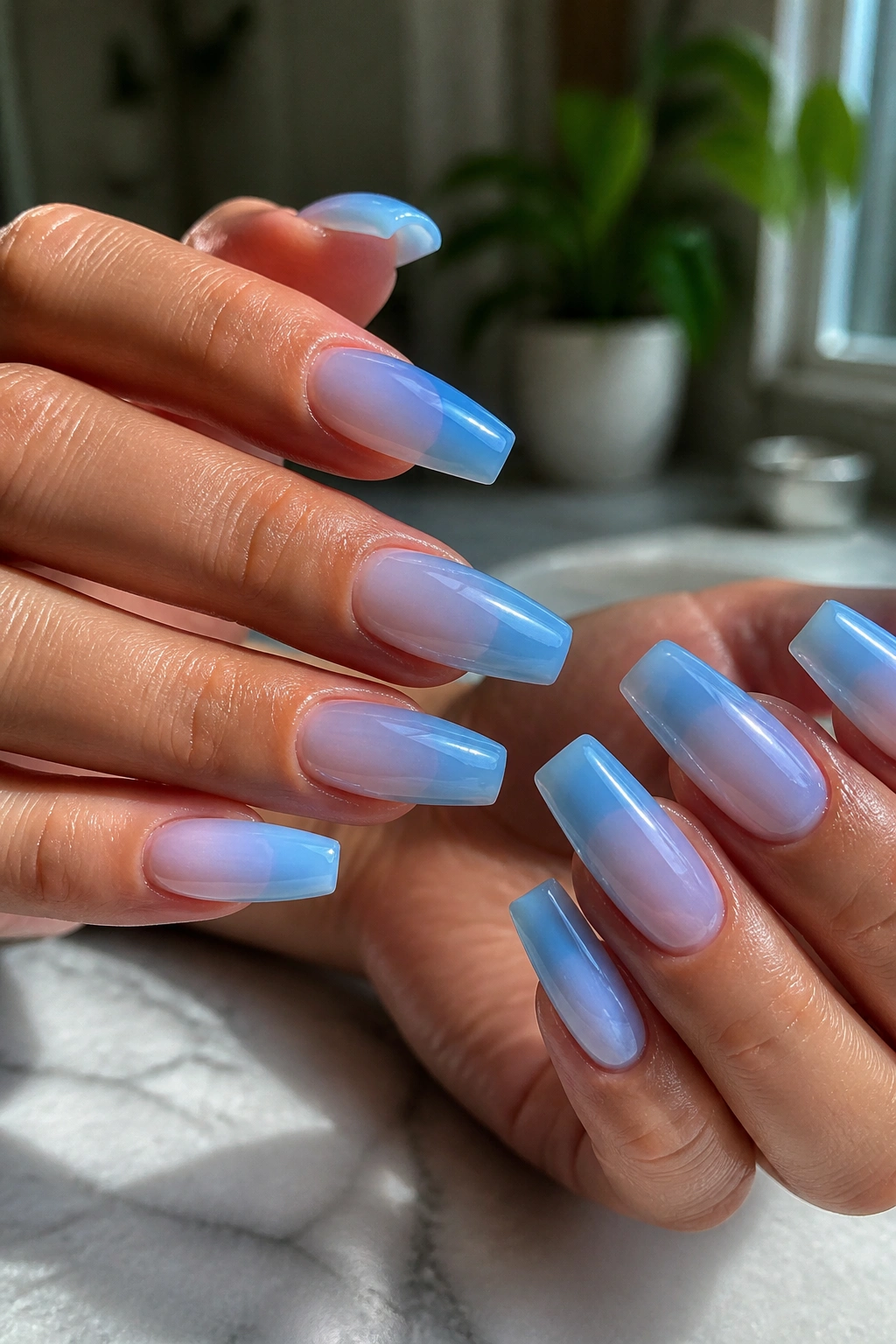 Close-up of translucent jelly blue coffin nails on real hands in natural light