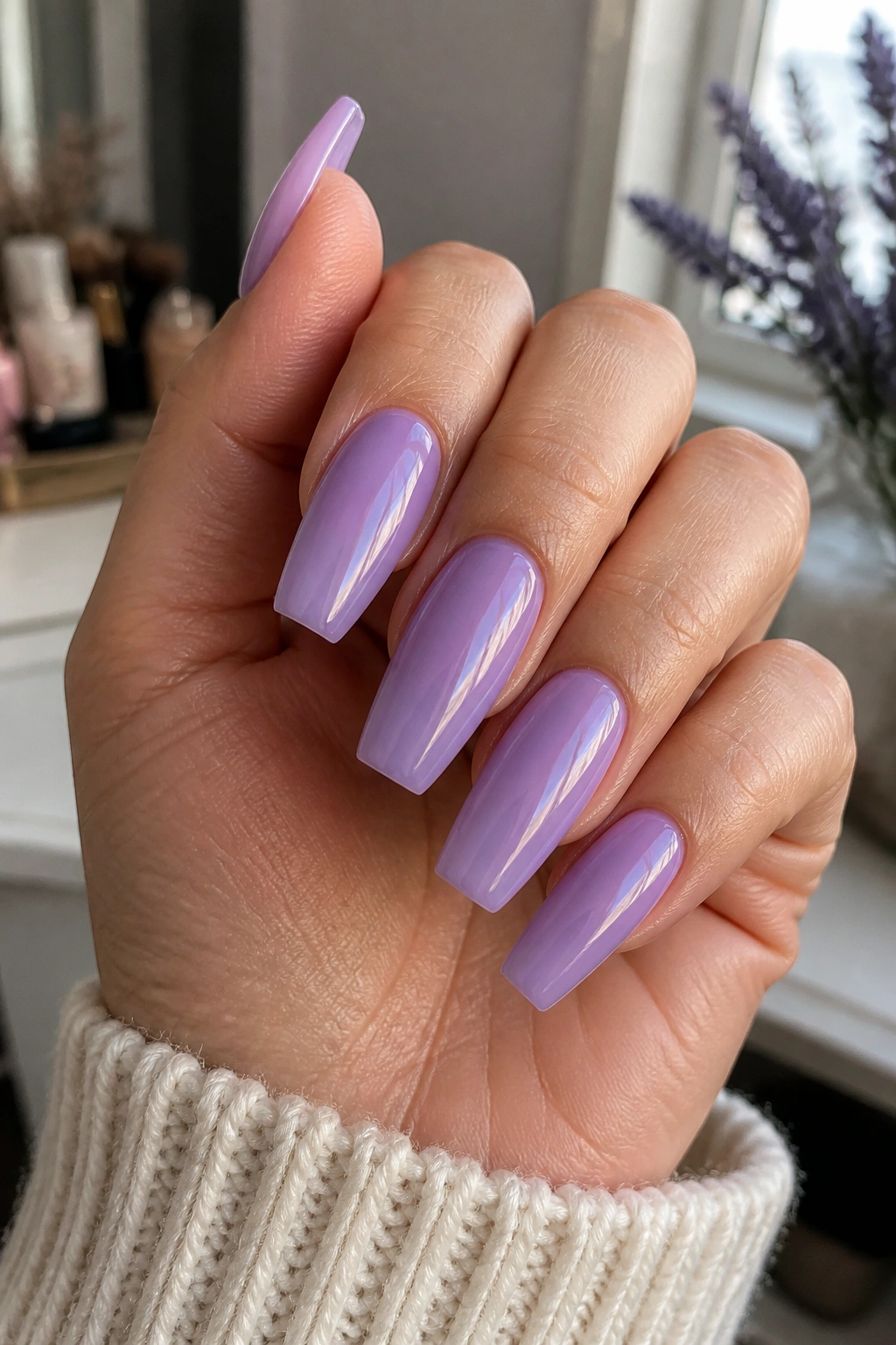 Close-up of coffin nails in sheer lavender jelly, translucent glossy nails on a real hand