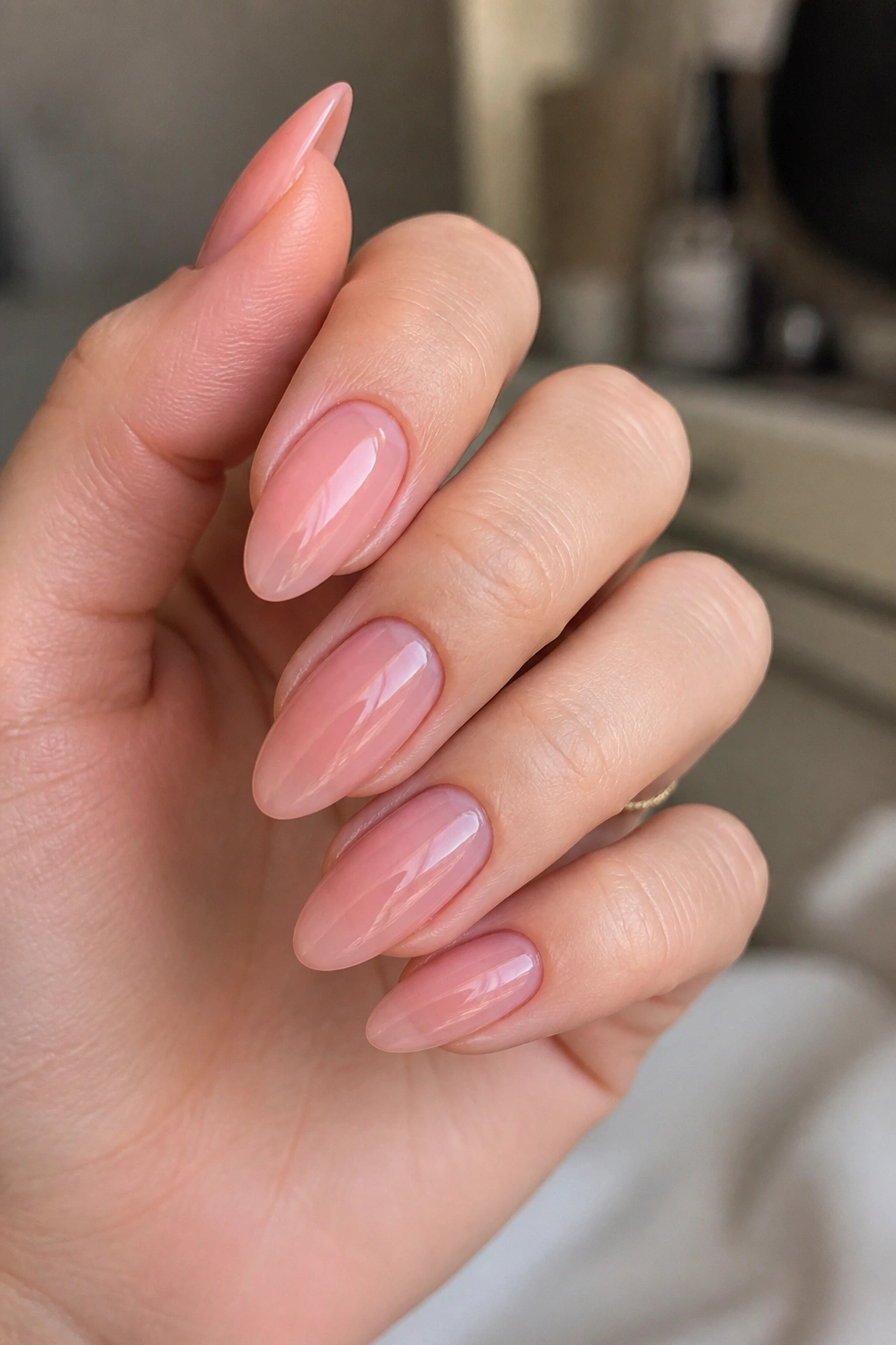 Close-up of translucent blush jelly nails on almond nails with depth