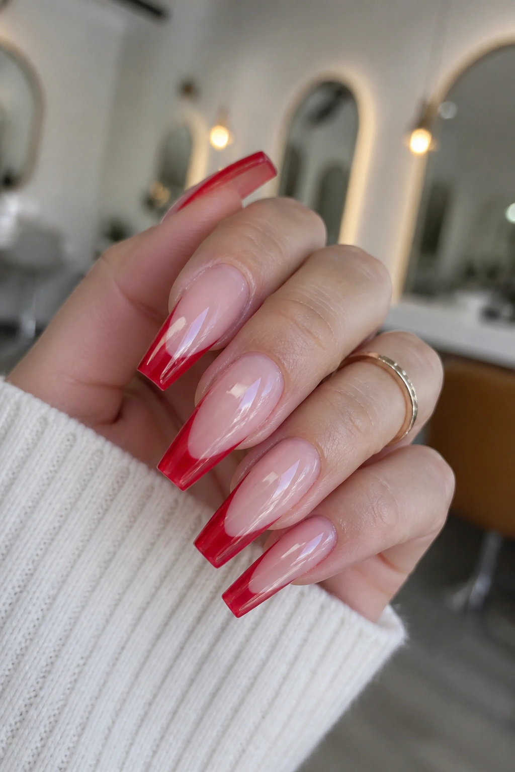 Close-up of jelly red French tips over sheer pink builder base on a real hand