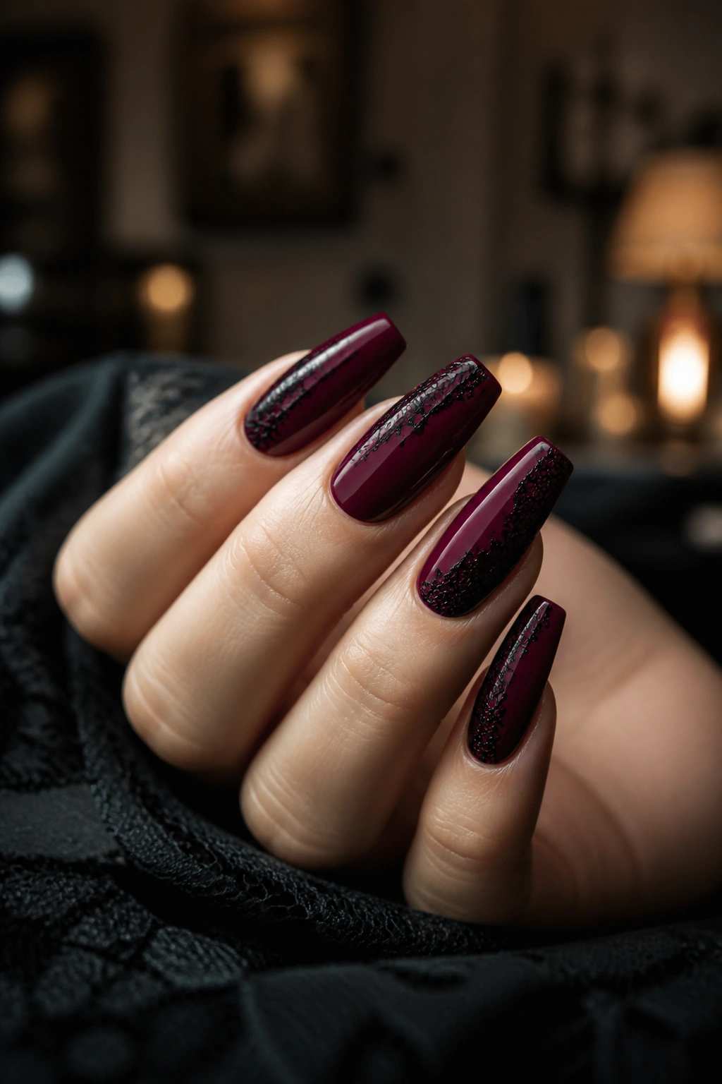 Wine red coffin nails with black lace detailing on a real hand