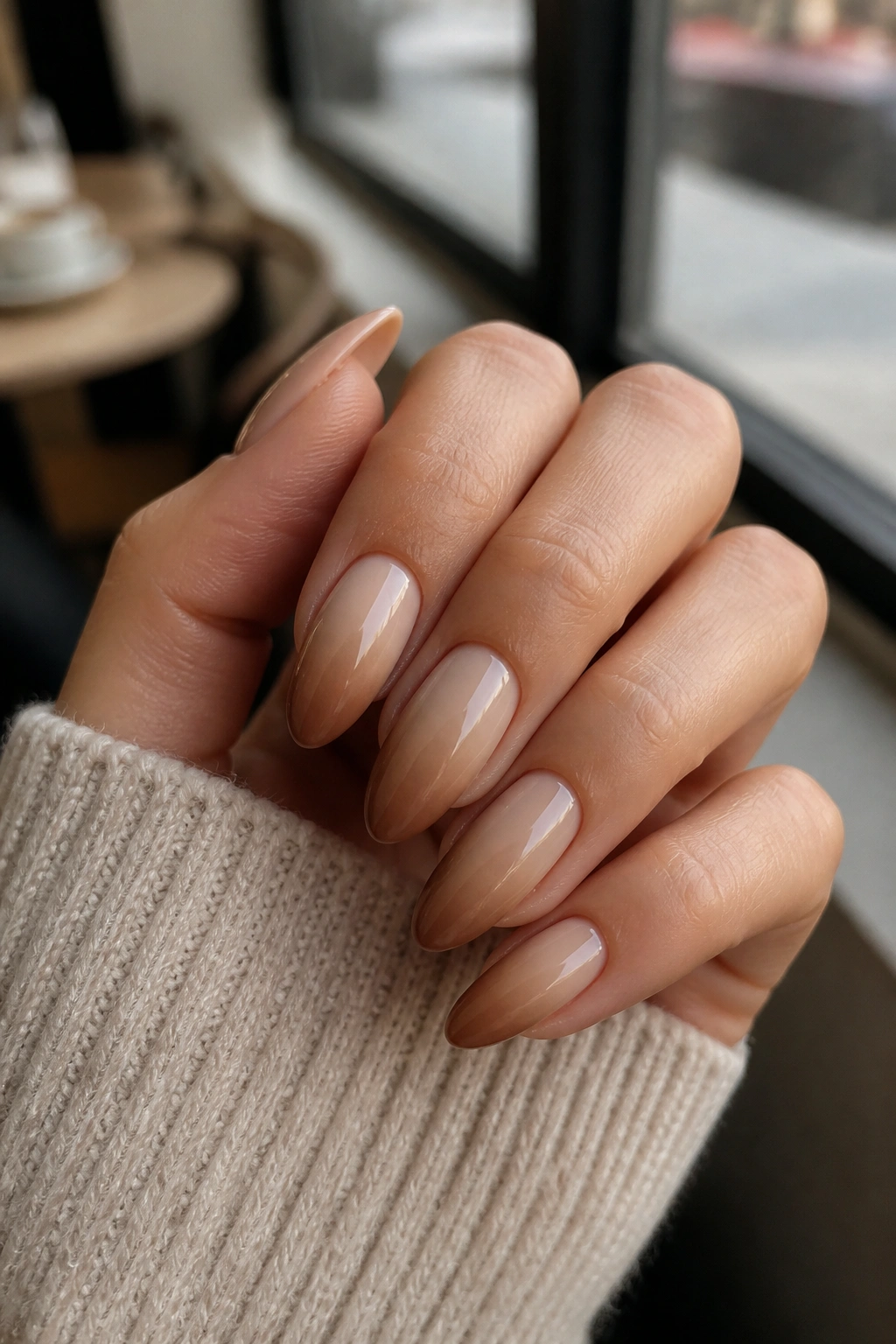 Close-up of latte ombre almond fade nails on a real hand