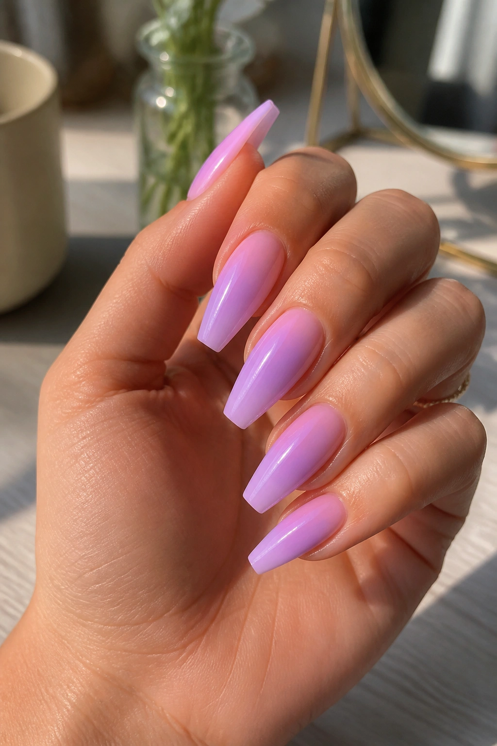 Close-up of real hand with lavender-to-pink aura coffin nails