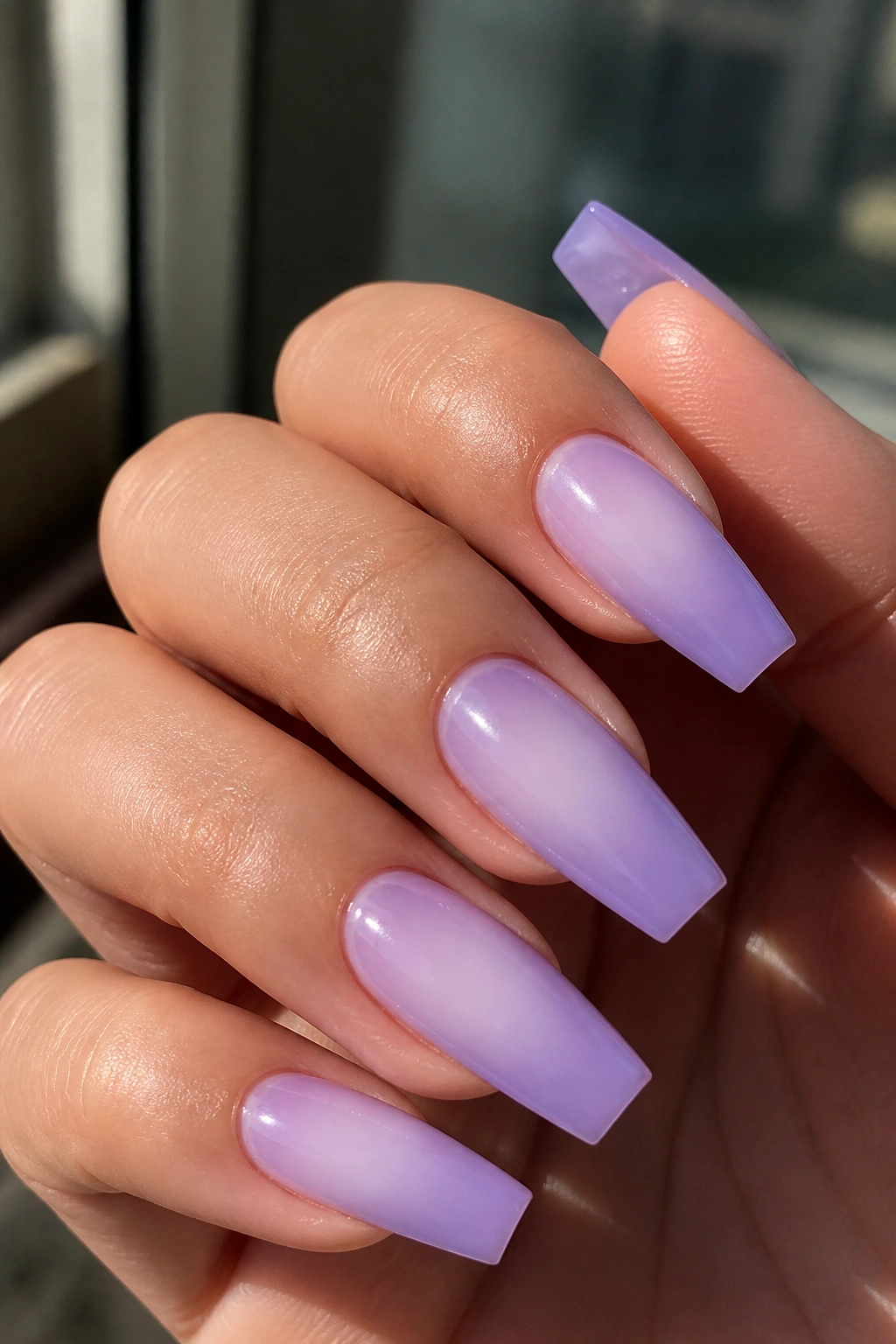 Close-up of lavender aura nails with diffused glow on a real hand