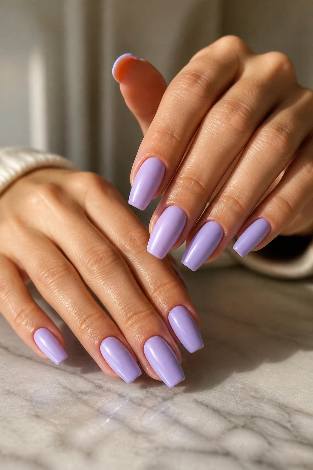Close-up of lavender coffin nails on a real hand with milky finish