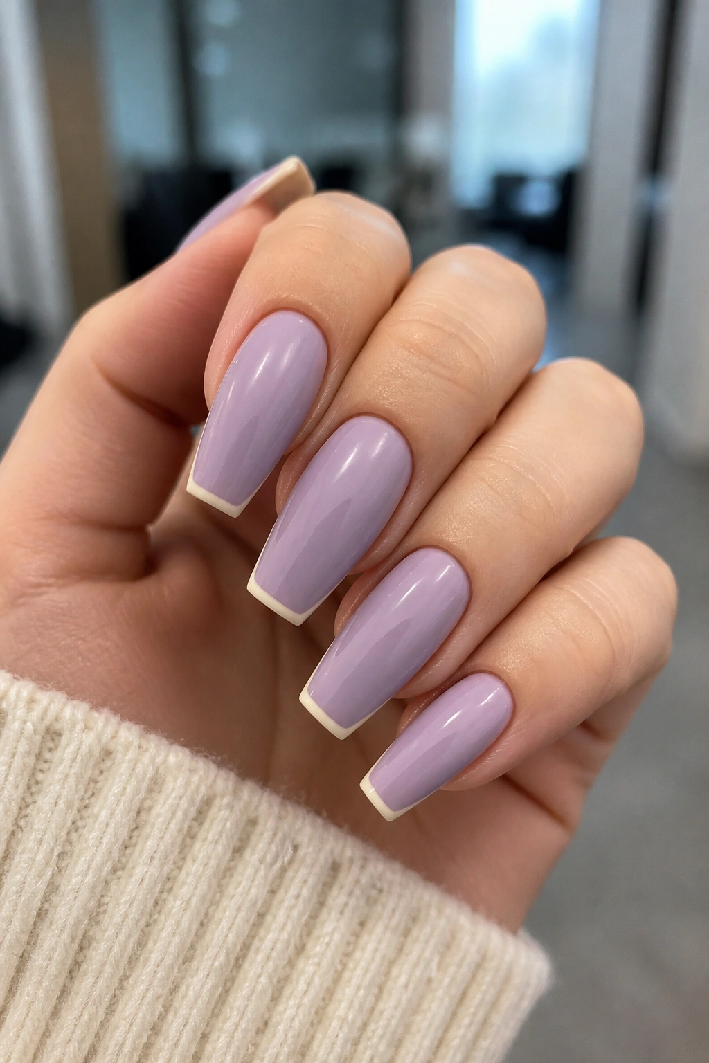 Close-up of lavender and cream micro-tip coffin nails on a real hand