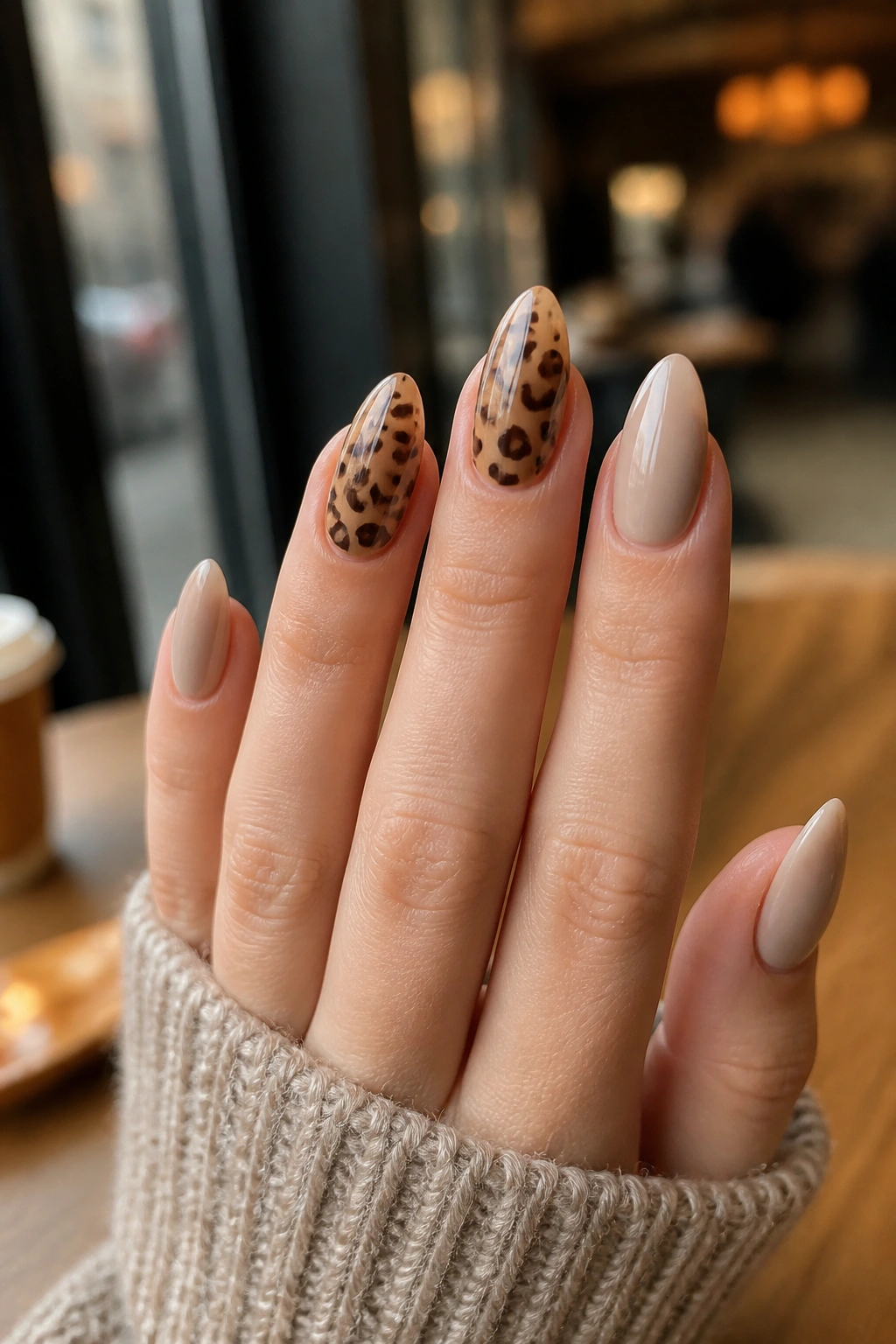 Close-up of leopard print almond nails on a real hand with accent nails.