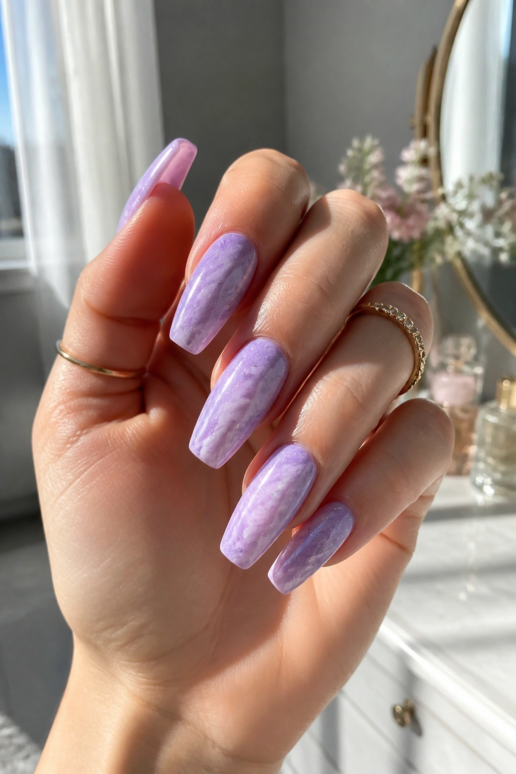 Close-up of lilac marble coffin nails with micro glitter on a hand