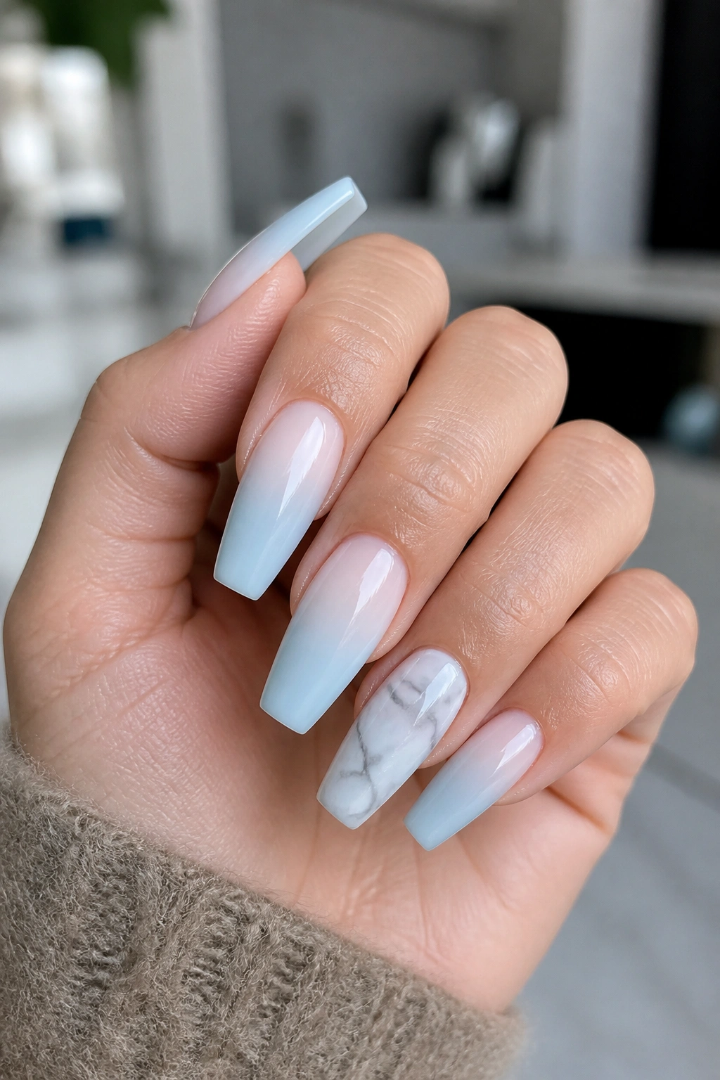 Close-up of marble accent blue ombre coffin nails on a real hand