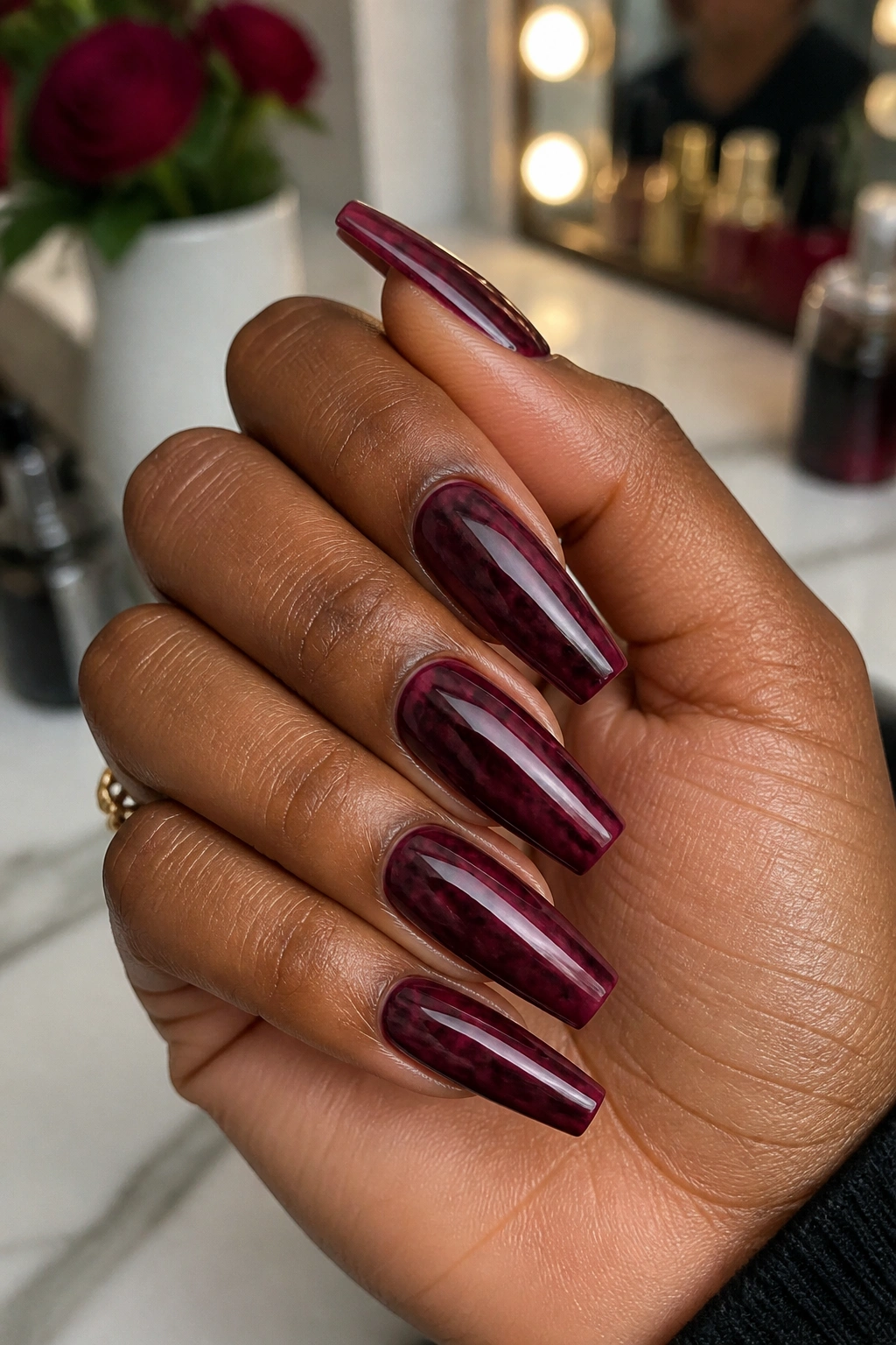 Close-up burgundy tone-on-tone marble coffin nails on a real hand