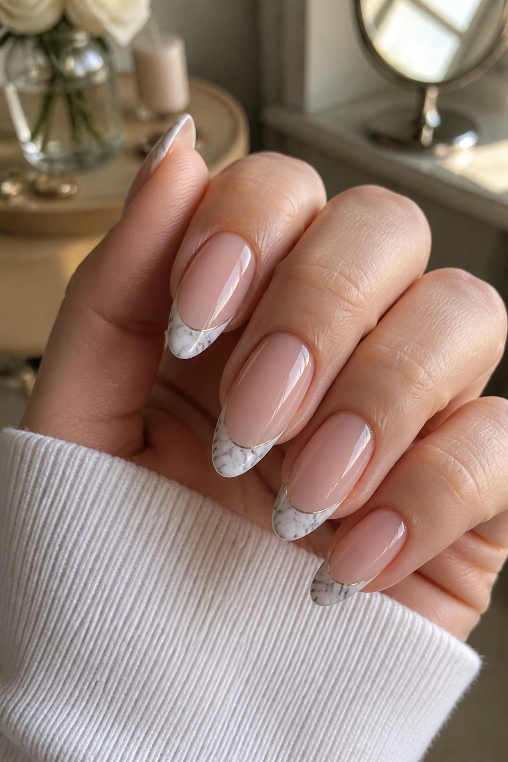 Close-up of almond nails with marble French tips on nude base