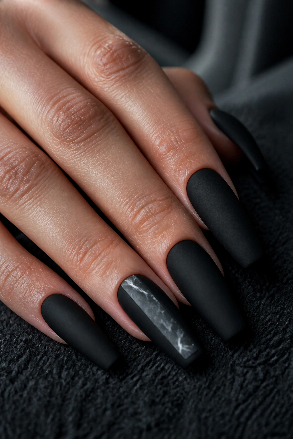 Close-up of matte black coffin nails with a vertical marble panel accent