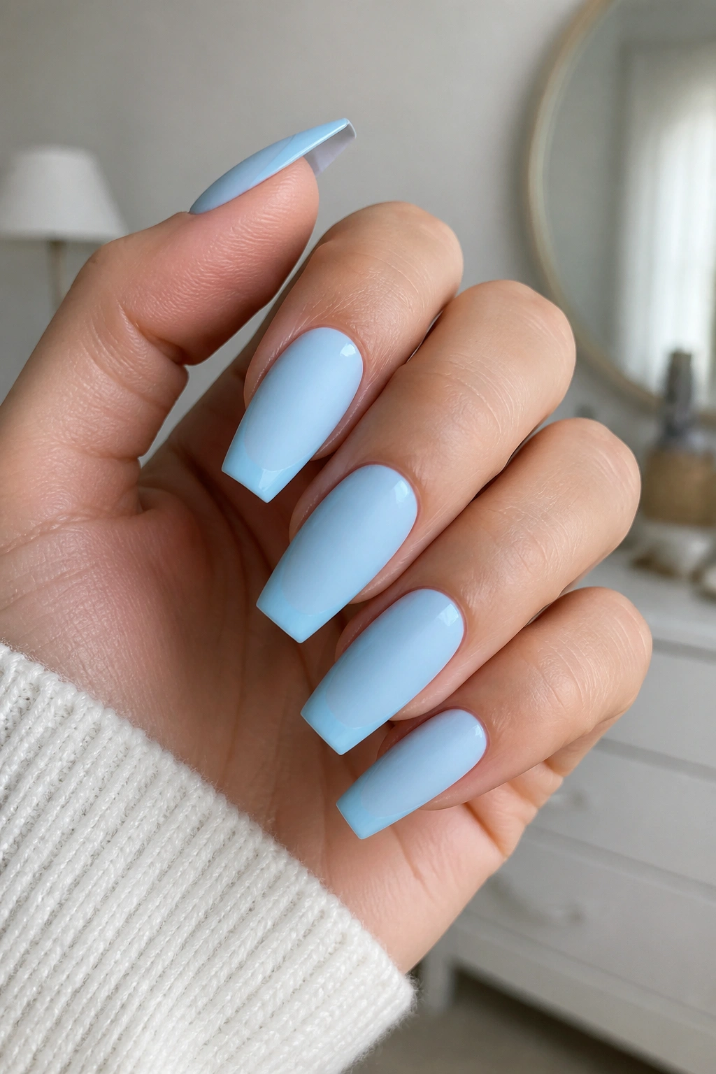 Real hand with matte blue coffin nails and glossy tips