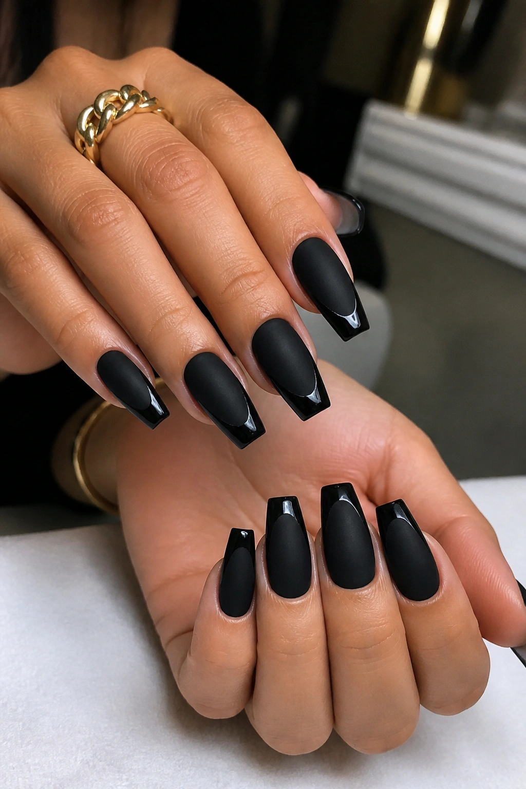 Matte black coffin nails with glossy French tips on a real hand.