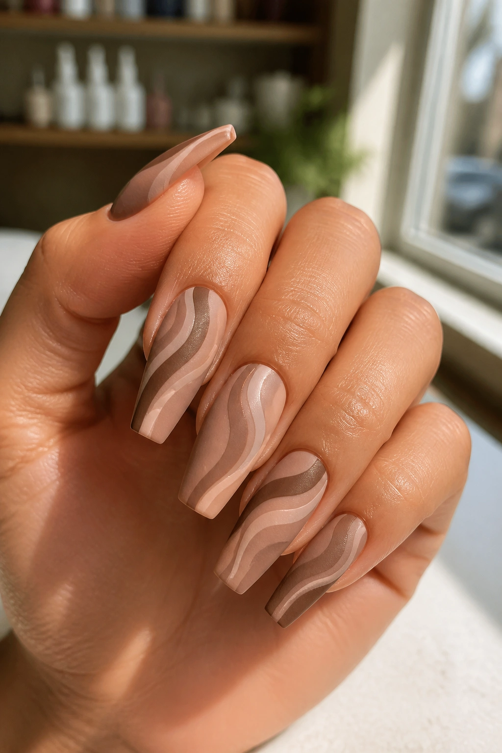 Close-up of matte mocha swirl nails on medium coffin nails