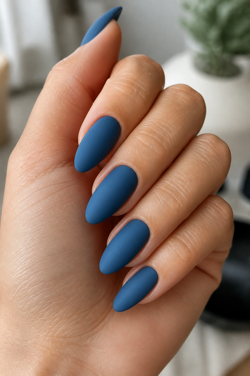 Almond nails with matte denim blue finish on real hand